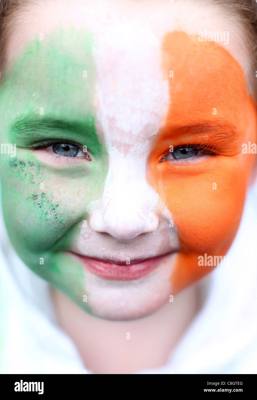 Un giovane ragazze con la bandiera irlandese dipinto sul suo viso sorrisi durante la St.Patrick parata del giorno a Dublino, Irlanda Foto Stock
