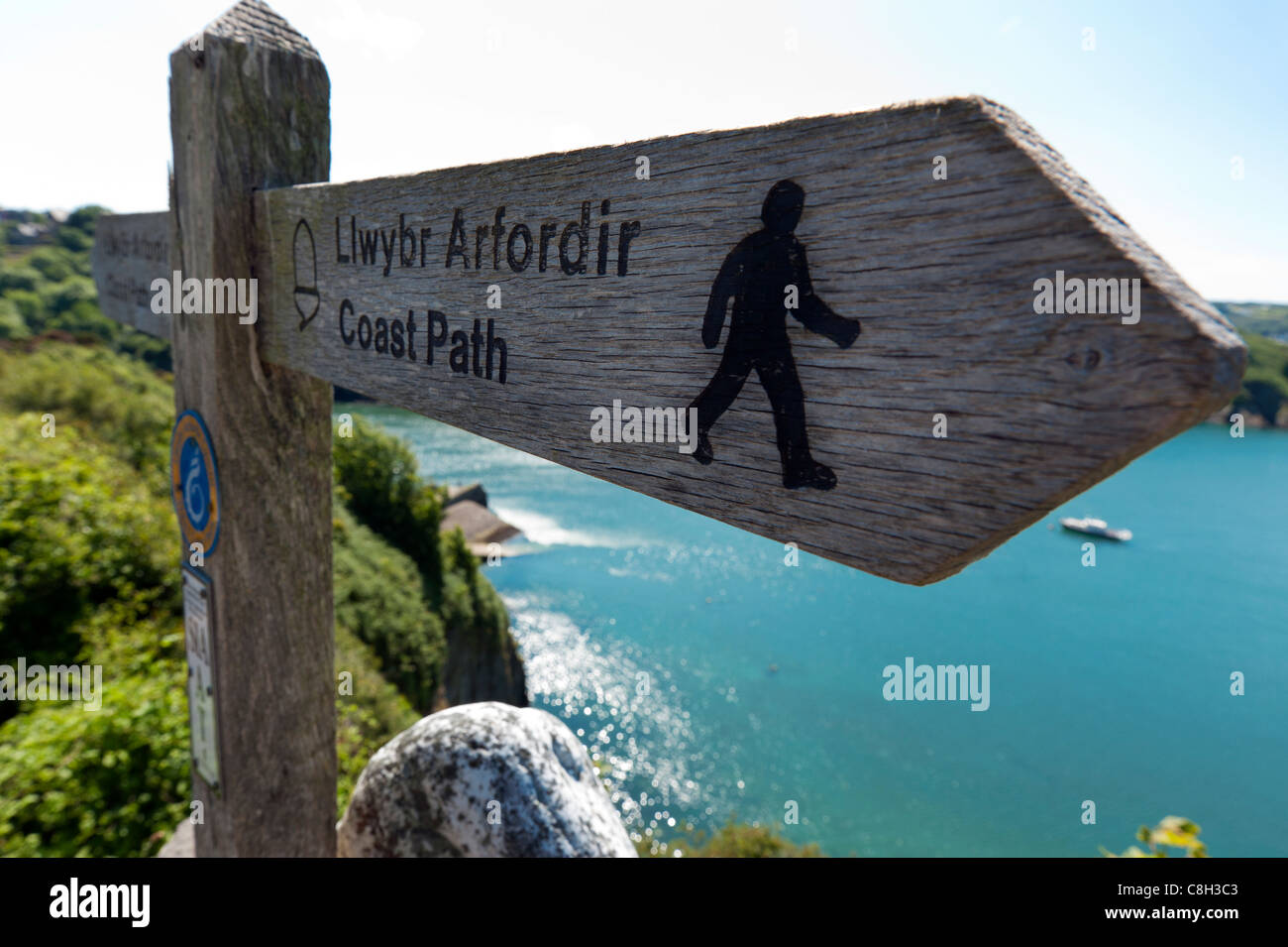 Segno che indica la direzione del Pembrokeshire sentiero costiero come passa basso Townn Porto, Fishguard, West Wales. Foto Stock