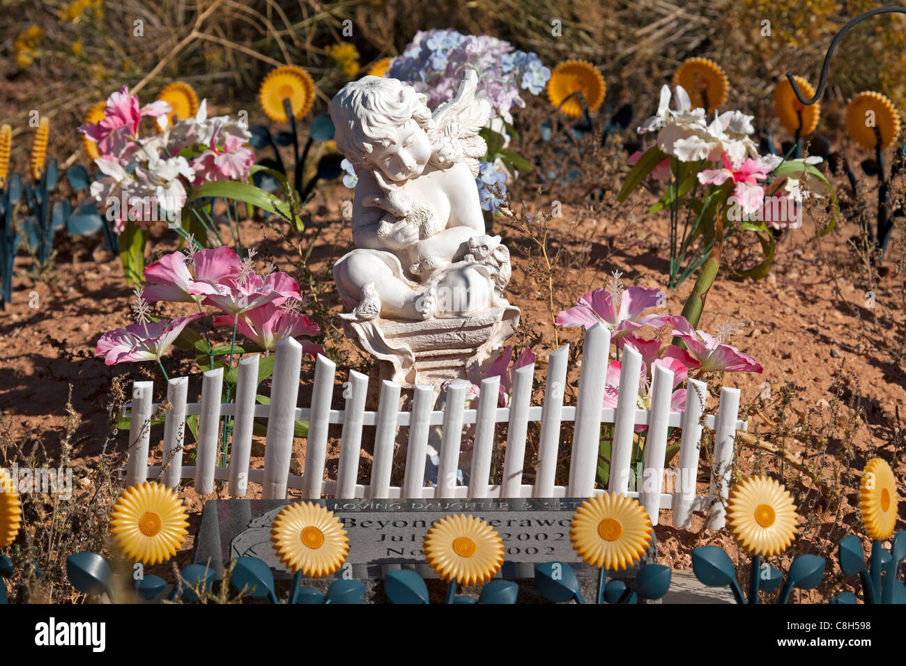 Angelo fiori e piccolo recinto bianco su una tomba di una piccola ragazza. Vecchio pioneer erbaccia e trascurato Fort Duchesne cimitero. Foto Stock