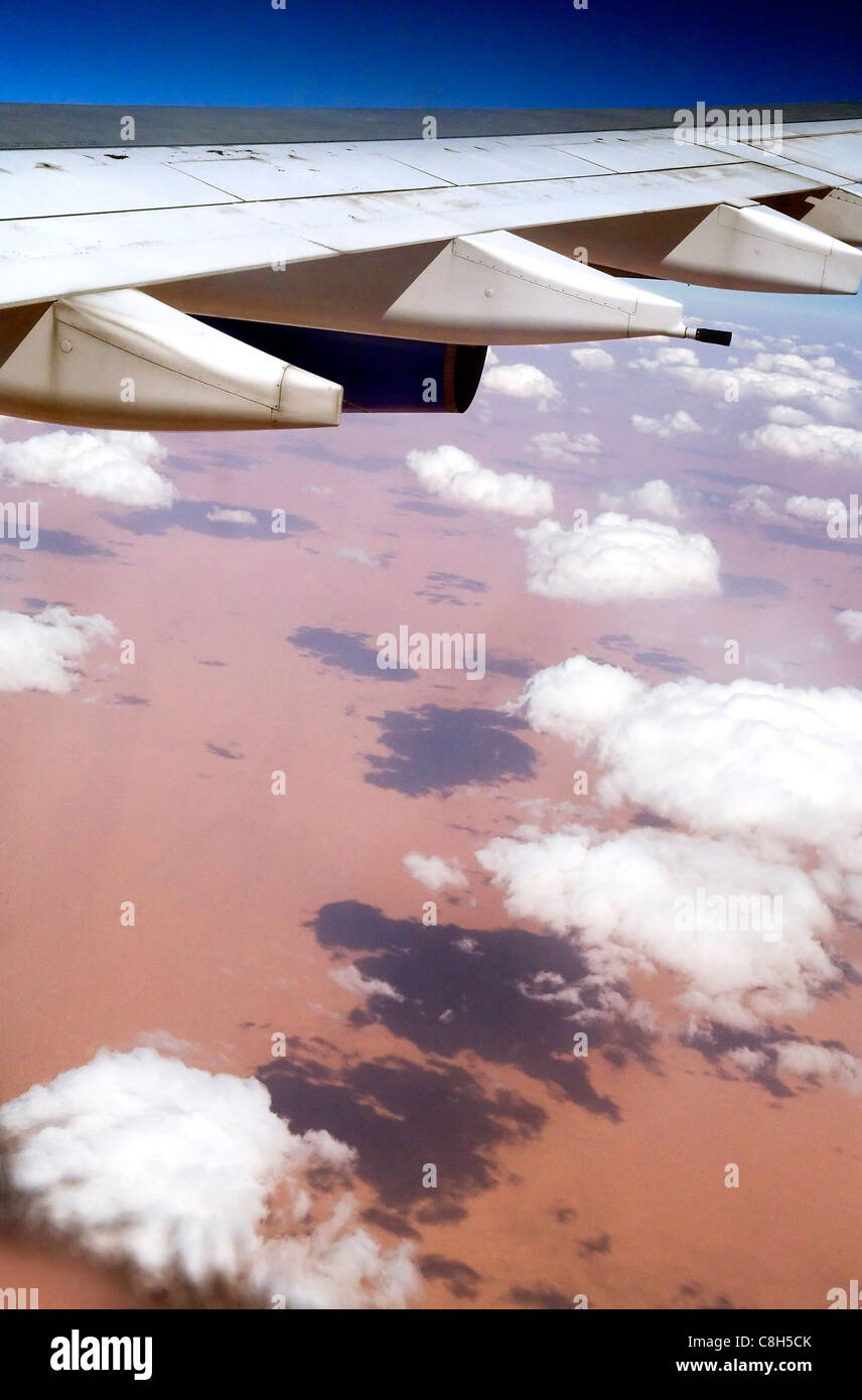 Un getto ala sorvola il Sahara, come le nuvole proiettano ombre sulla sabbia Foto Stock