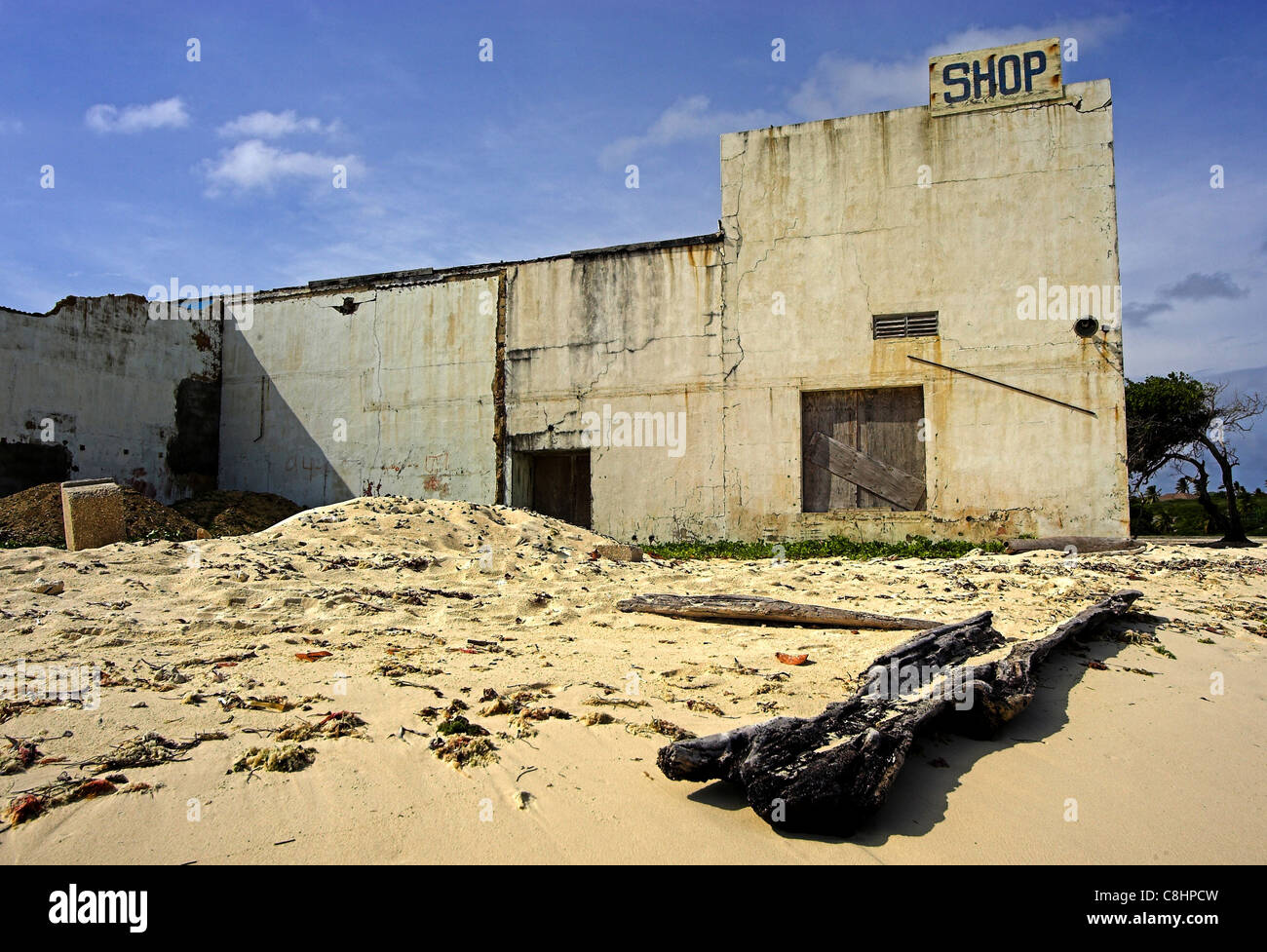 Edificio abbandonato sulla spiaggia di baby beach ad Aruba con un grosso pezzo di legno di drift e la spazzatura in shot. Foto Stock