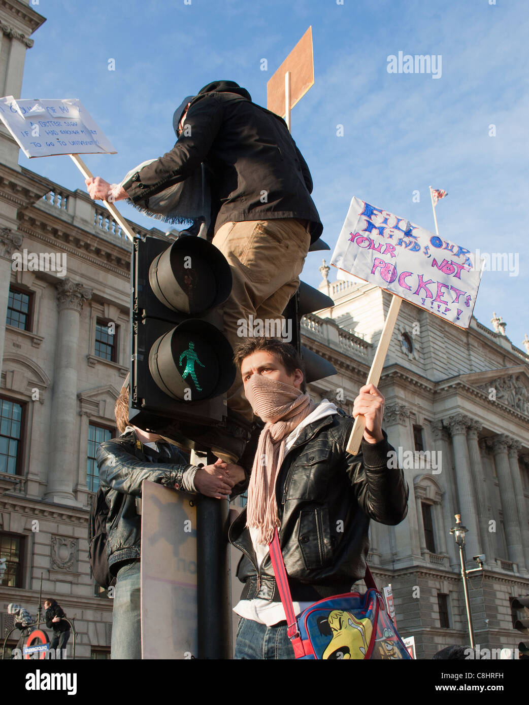 Studente contestatori salire sul semaforo con cartelli durante le tasse degli studenti proteste in Parlamento Square Londra 9/12/2010 Foto Stock