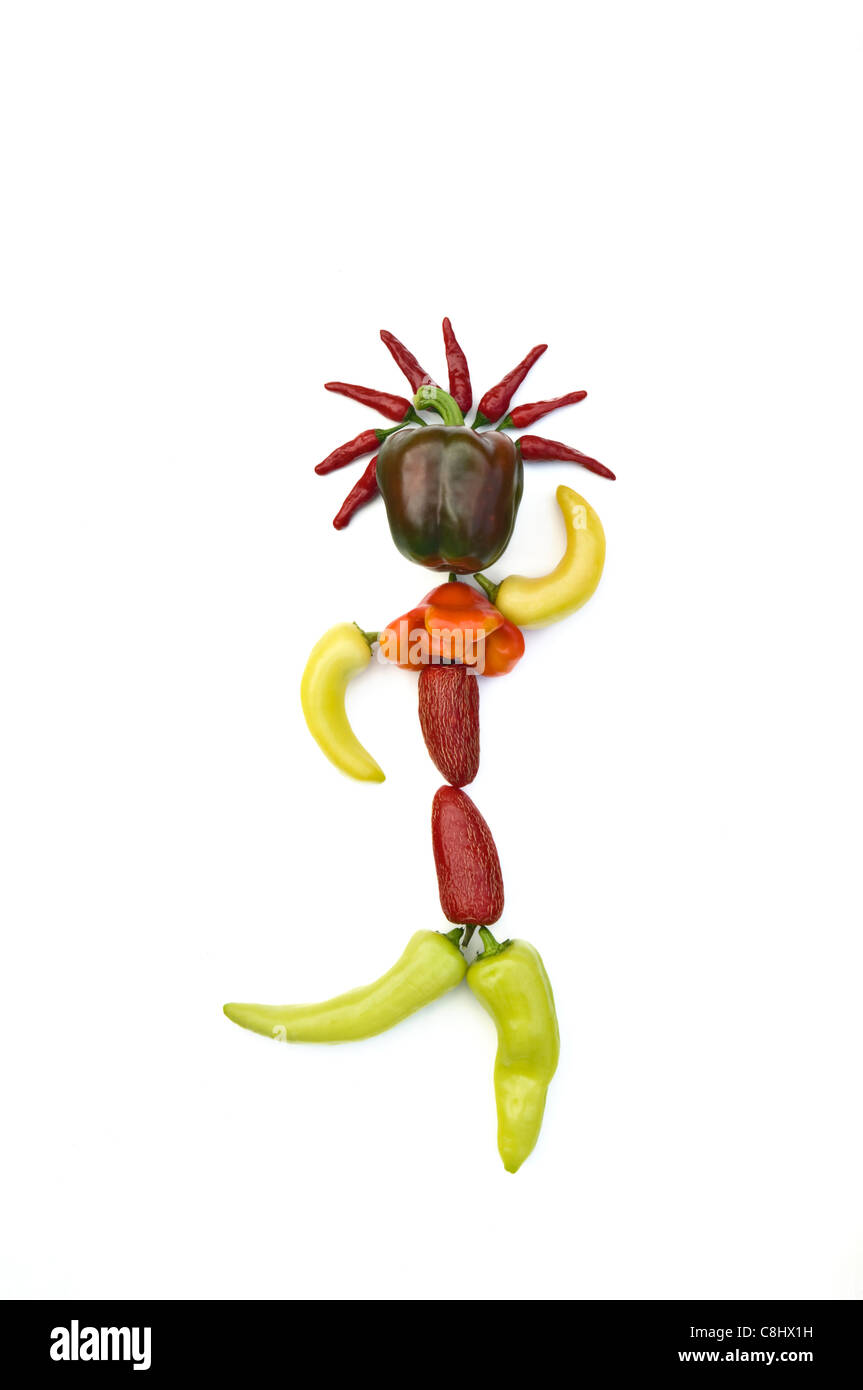 Diverse varietà di peperoni disposte per raffigurare una danza figura umana Foto Stock