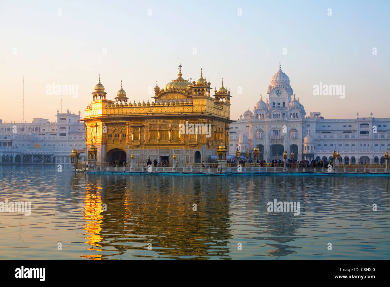 Gli ultimi raggi di sole e i Sikh Tempio d'oro nel suo lago ad Amritsar, in India nel Punjab membro Foto Stock