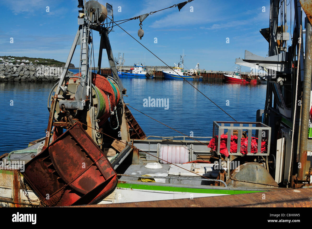 Un primo piano di una zona di pesca i pescherecci con reti da traino con  più navi per la pesca a strascico in background in Riviere aux Renard, in  Quebec, Canada Foto