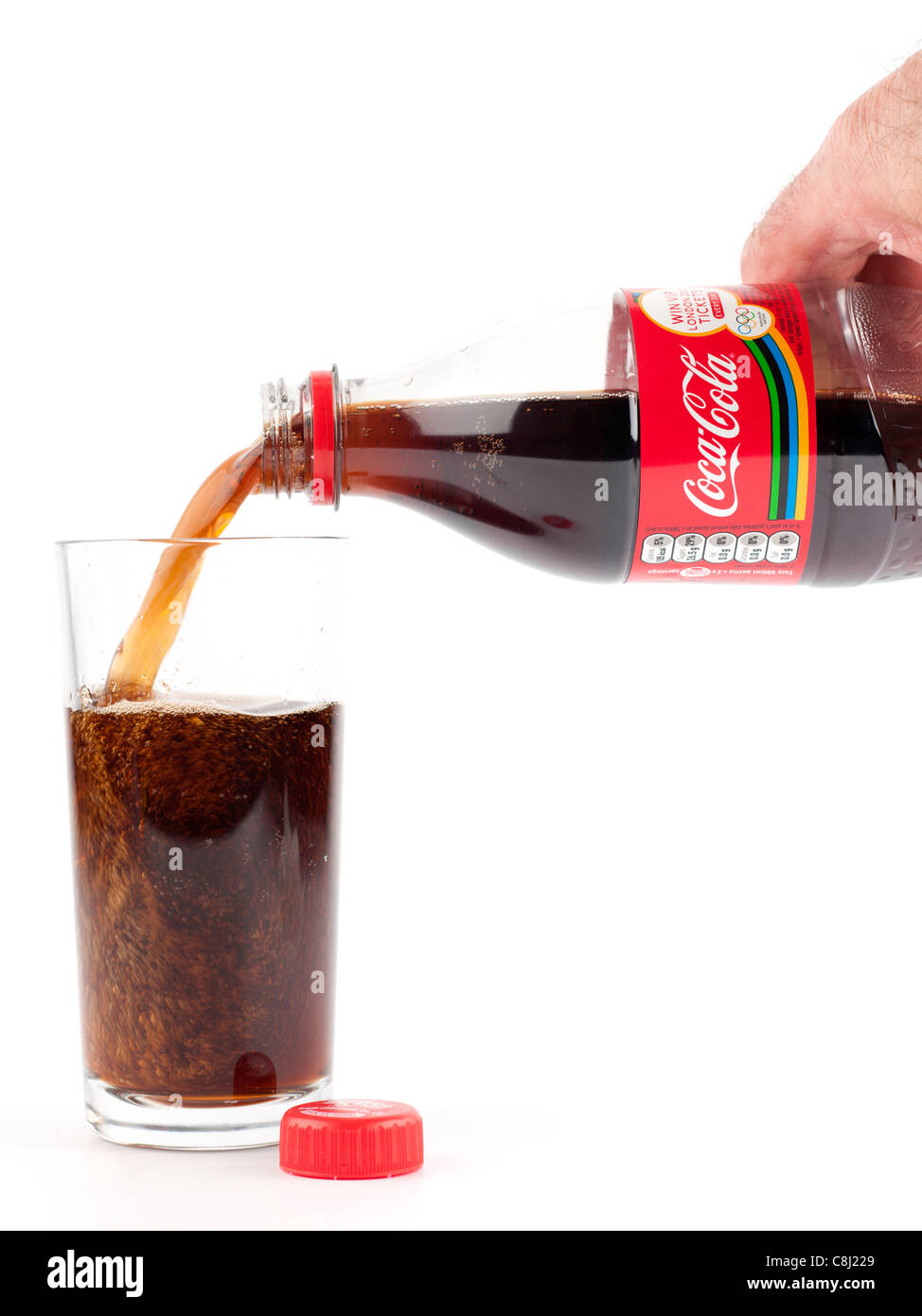 Bottiglia di Coca Cola è versata in un chiaro semplice vetro Foto Stock