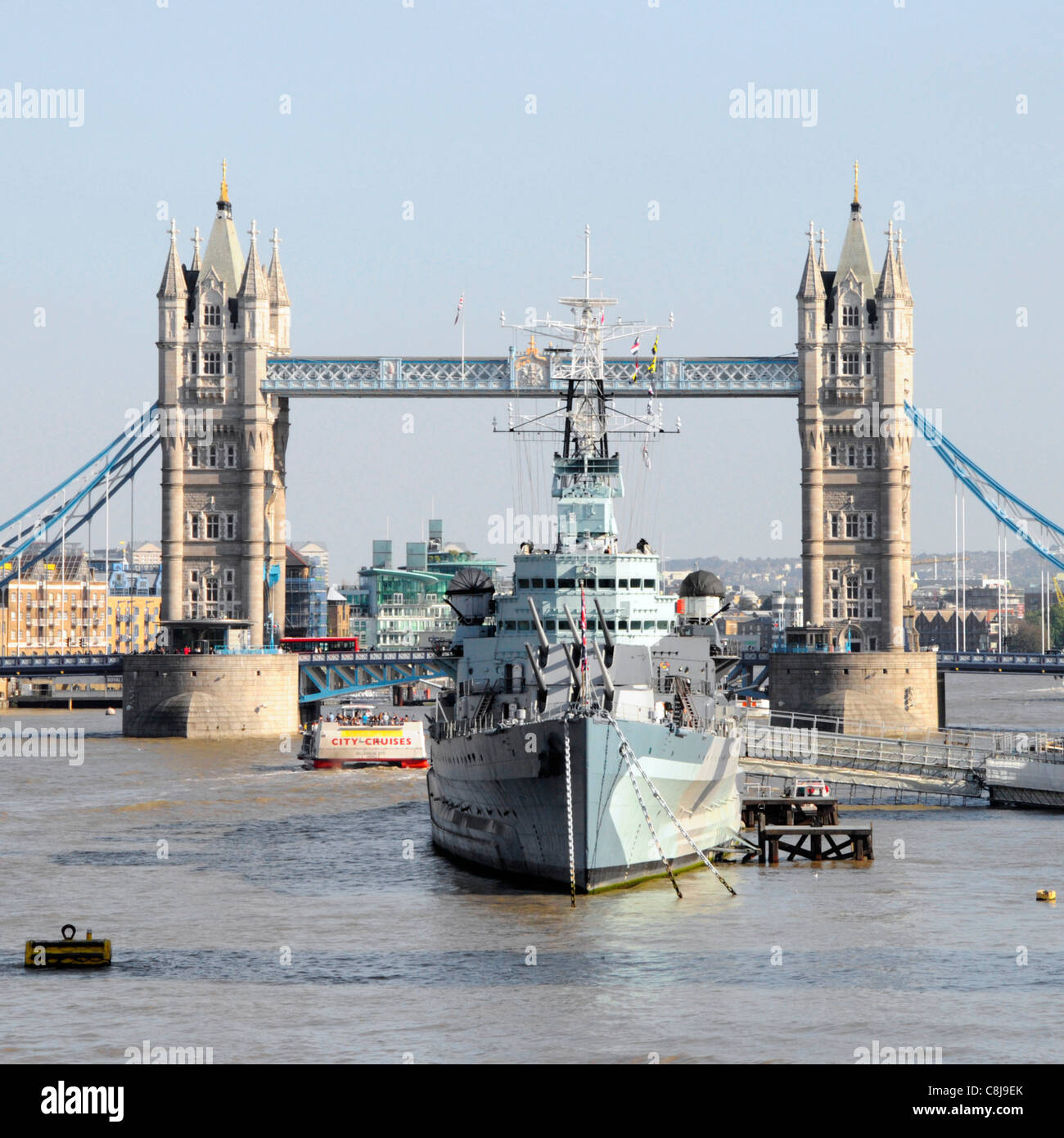 Incrociatore leggero HMS Belfast parte del Museo Imperiale della Guerra ormeggiata nel fiume Tamigi nel pool di Londra con iconico Tower Bridge oltre Londra Inghilterra REGNO UNITO Foto Stock