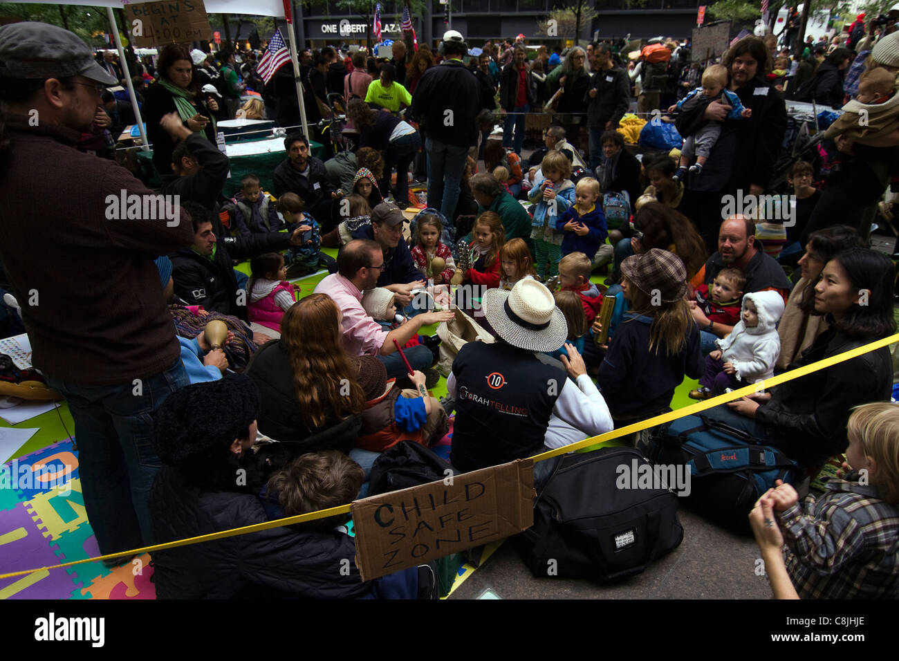 I genitori per occupare Wall Street raccogliere all'interno di Zuccotti Park con i loro figli e a partecipare in un cerchio del tamburo il Ott 21 Foto Stock