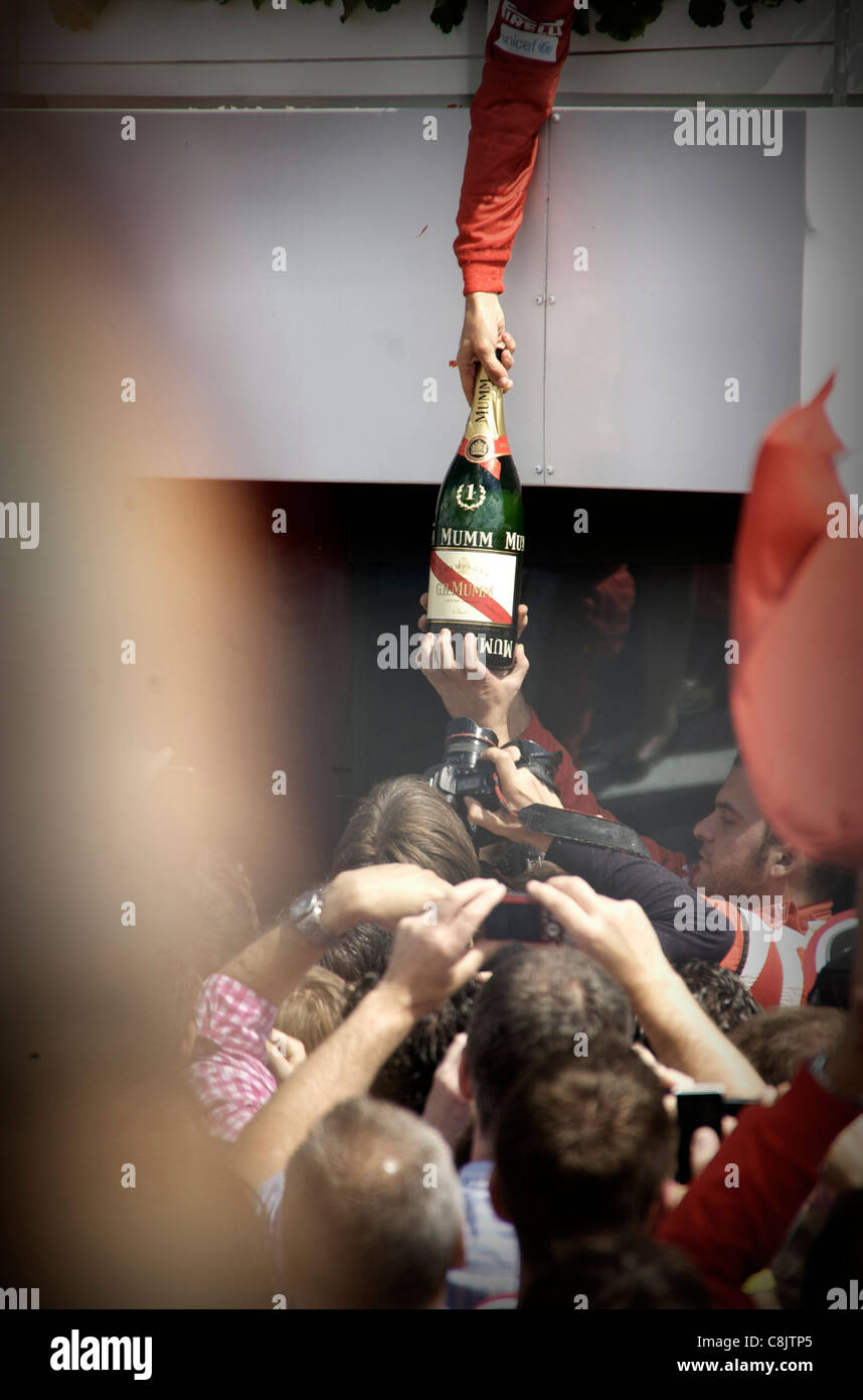 Fernando Alonso passa vincente il champagne ai compagni di squadra dopo aver vinto il British Formula 1 Gran Premio di Gran Bretagna a Silverstone Foto Stock
