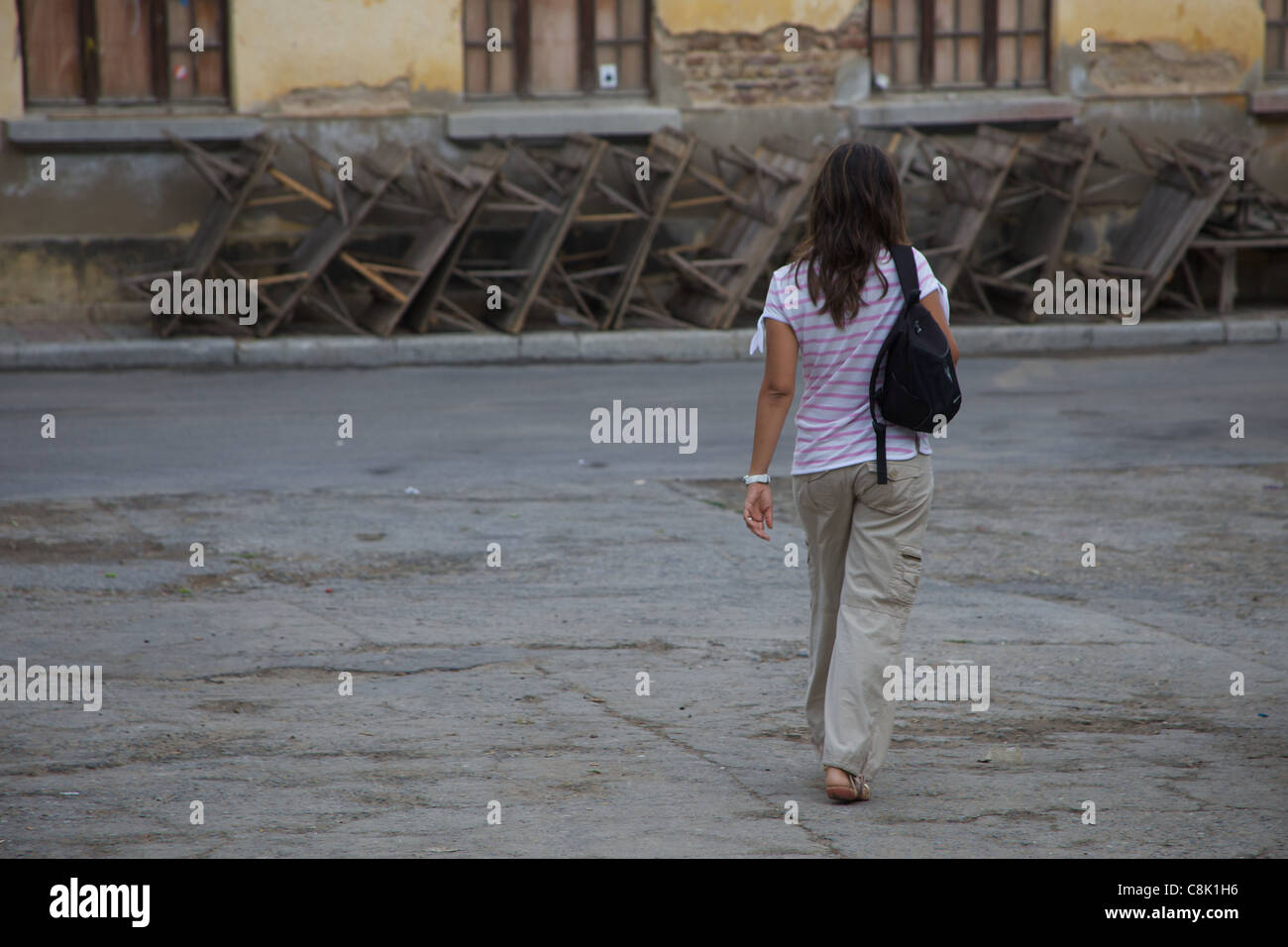 Giovane donna con capelli lunghi a piedi verso abbandonato la scuola greca sull'isola Heybeli, Istanbul, Turchia Foto Stock