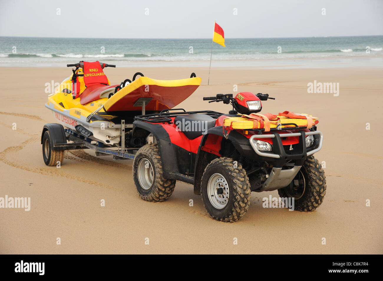 Cornovaglia, Inghilterra. Un bagnino RNLI quad bike e jet ski PWC mezzo di salvataggio su di una spiaggia di sabbia. Foto Stock