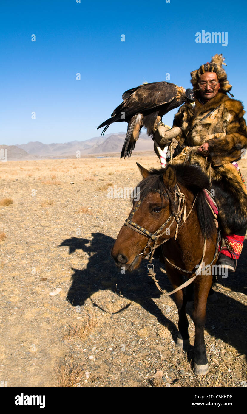 Un aquila kazaka cacciatore con il suo Golden Eagle in Altai regione della Mongolia occidentale. Foto Stock