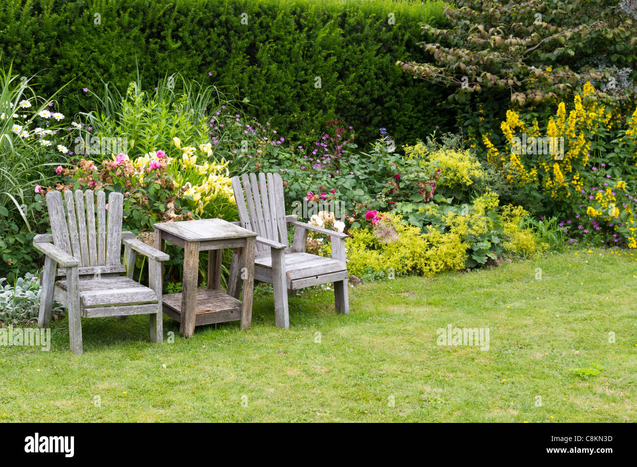 Una coppia di sedie e tavolino in giardino Foto Stock
