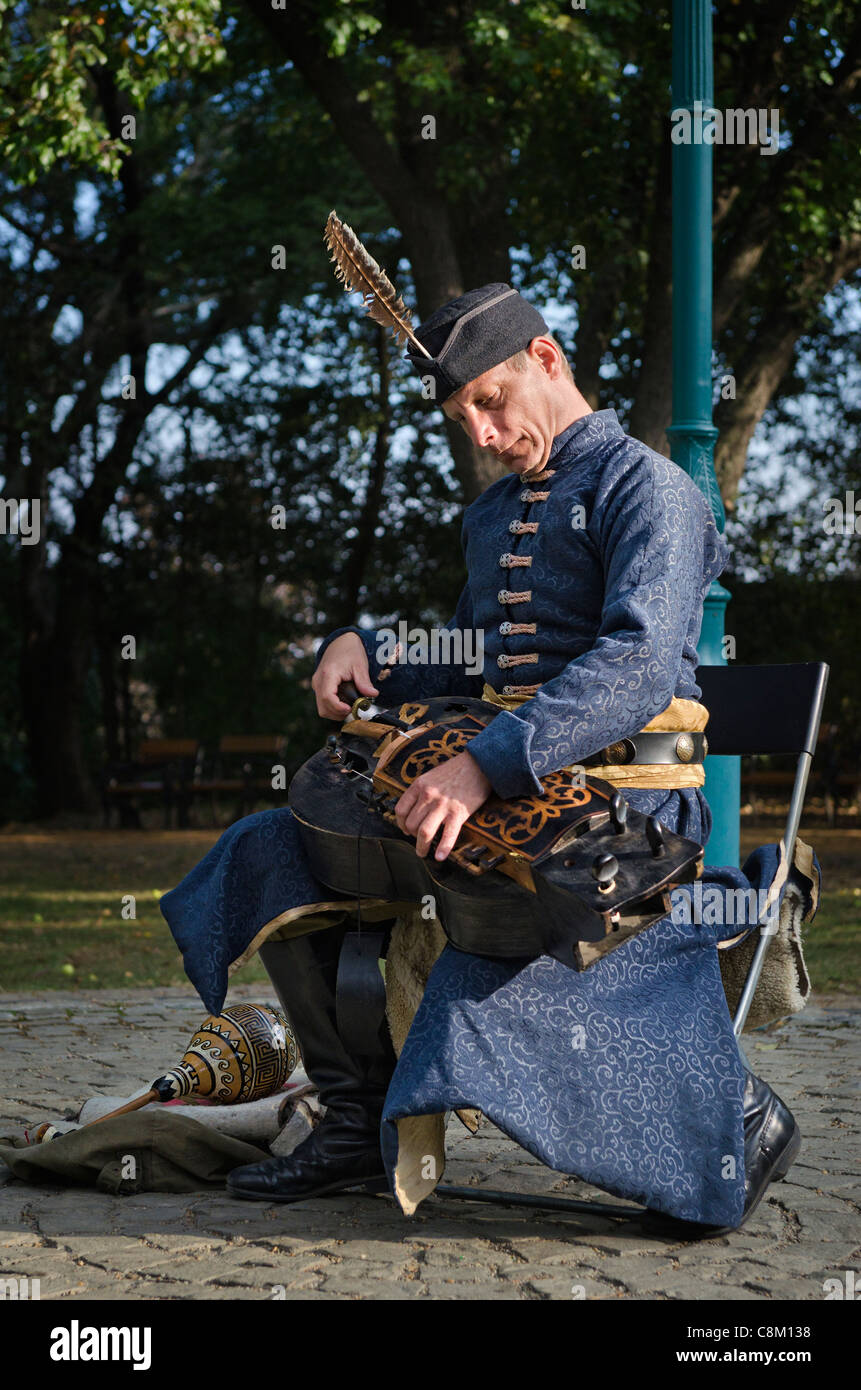 Musicista di strada in costume tradizionale riproduzione di un organetto di Barberia in un parco a Budapest Foto Stock