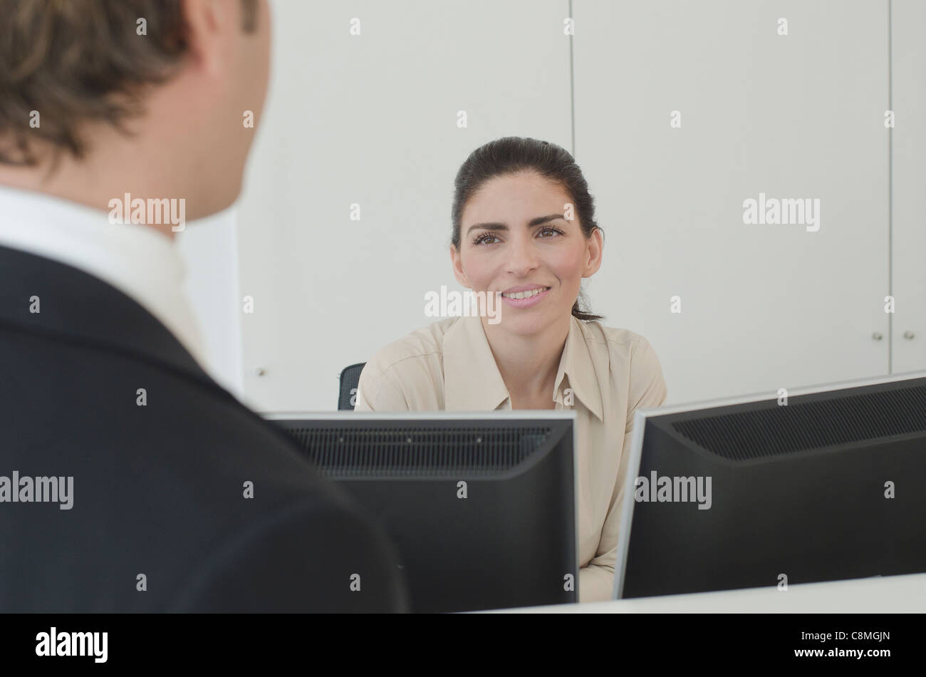 Imprenditore ispanica parlando a receptionist Foto Stock
