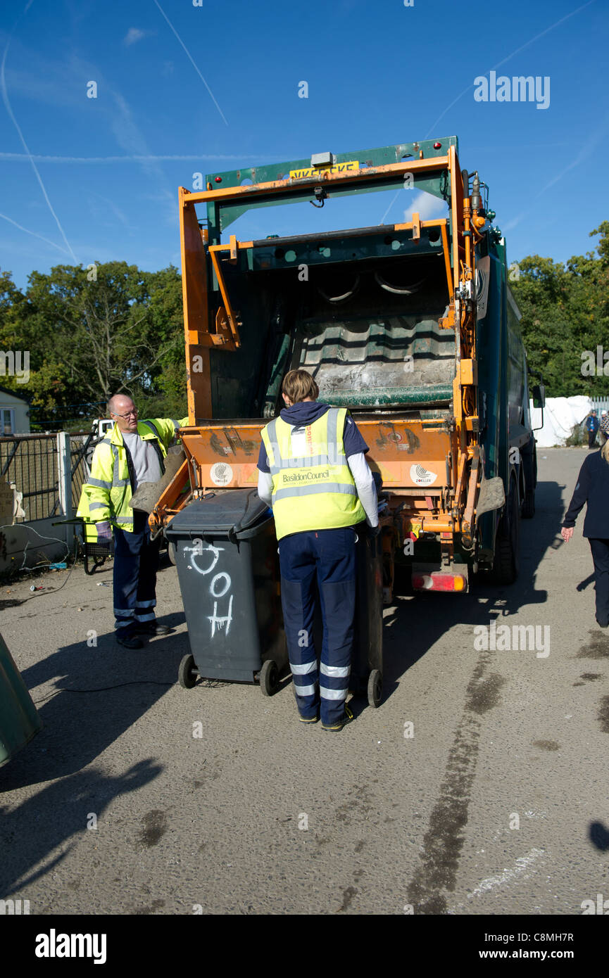 Rifiutare i lavoratori dal consiglio di Basildon Essex lavorando in corrispondenza della parte posteriore della polvere carrello di caricamento e svuotamento wheely (gommati) bin in retro. Foto Stock