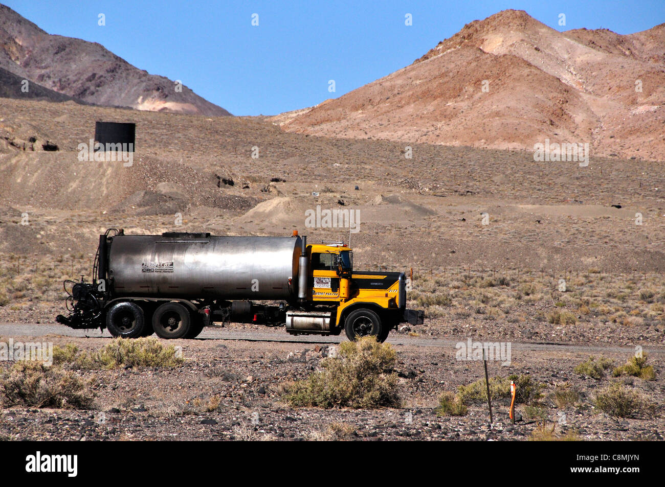Asfalto carrello distributore vicino a una strada in costruzione sito su autostrada 95, Nevada Foto Stock