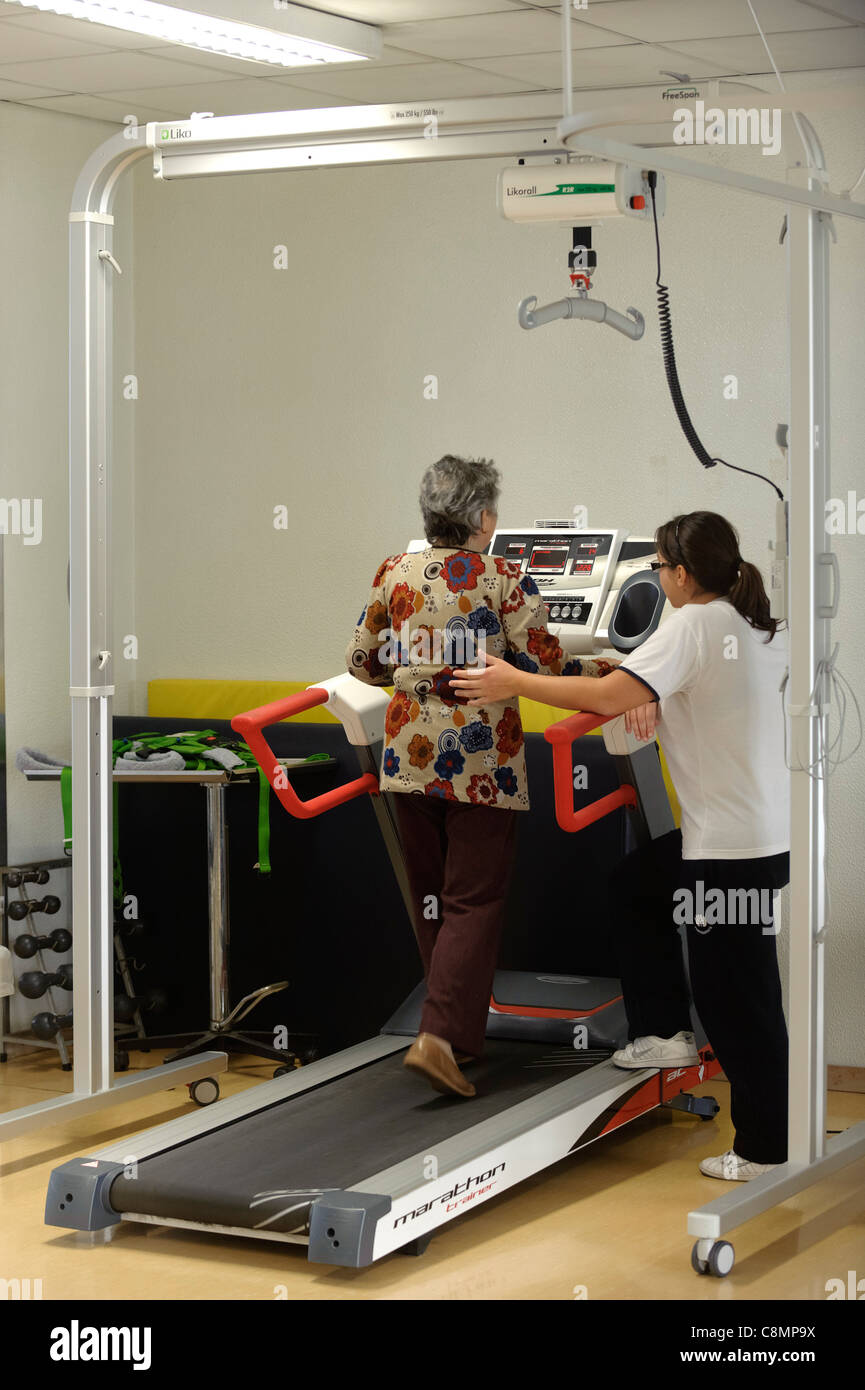 Fisioterapista aiuta la donna a piedi sul tapis roulant sulla riabilitazione  fisica palestra Foto stock - Alamy