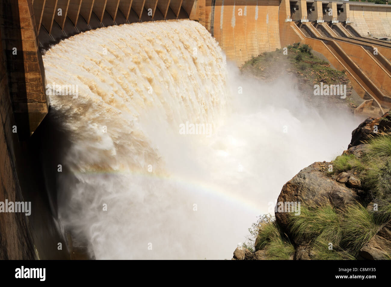 Forte che scorre acqua rilasciata dall'apertura paratoie di una diga di grandi dimensioni Foto Stock