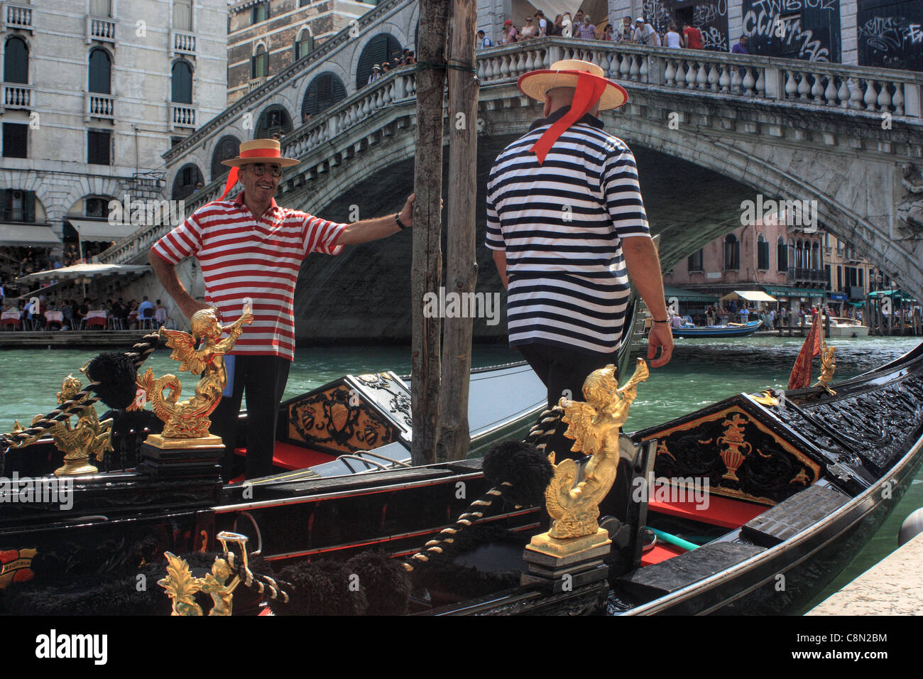 Gondolieri a Venezia, Italia. Due gondolieri nella parte anteriore del ponte di Rialto. Foto Stock