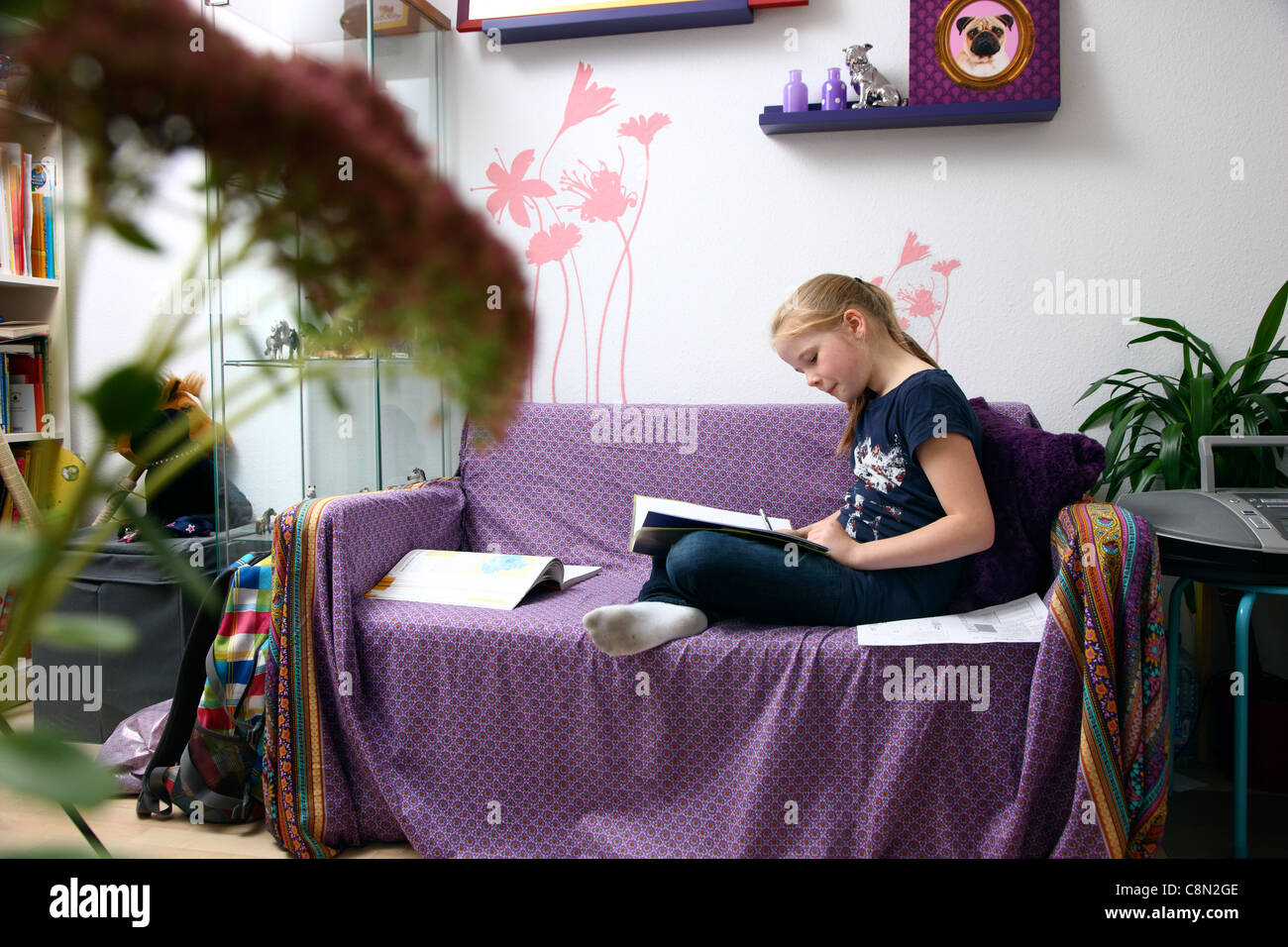 Ragazza, 10 anni, di apprendimento per la scuola, a casa nella sua stanza, studiare. Foto Stock