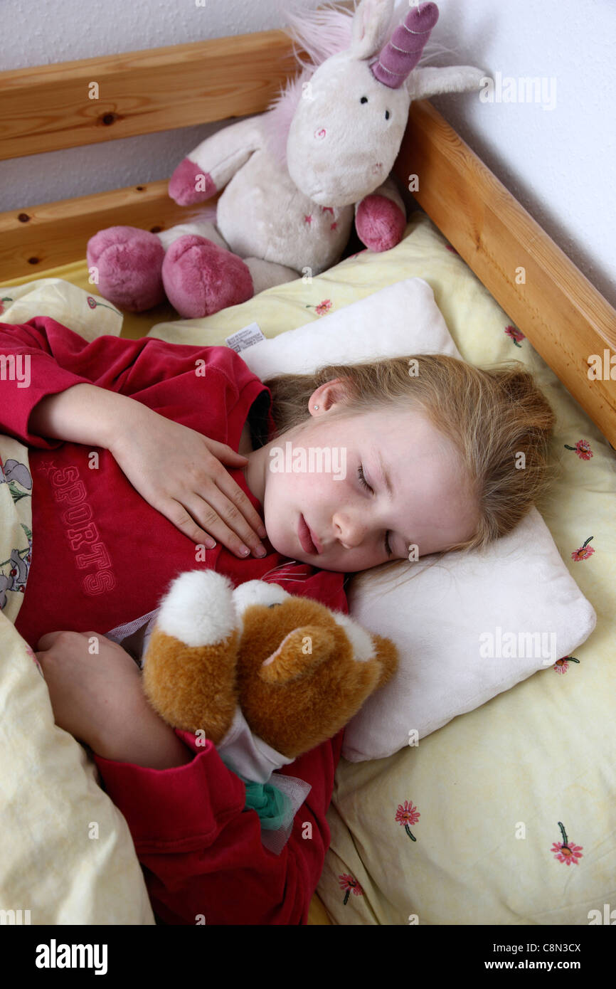 Ragazza giovane, 10 anni, giace ammalata nel letto con un influenza. Avendo un mal di gola. Foto Stock