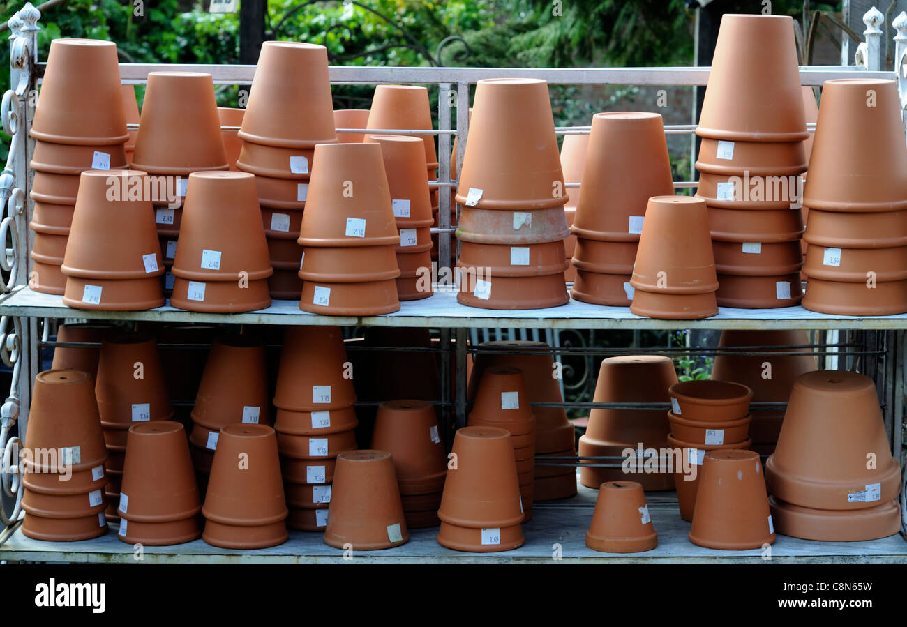 Vasi di terracotta pot giardinaggio giardino pila di contenitori impilati righe ripiani accantonato garden center shop Foto Stock