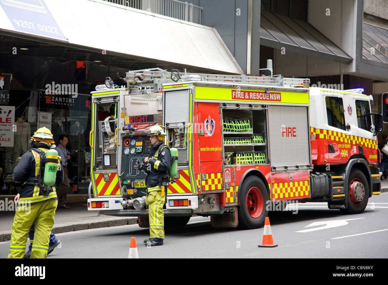 Motore di soccorso per camion dei Vigili del fuoco in Hunter Street, Sydney, Australia, con vigili del fuoco in indumenti protettivi e attrezzature respiratorie Foto Stock