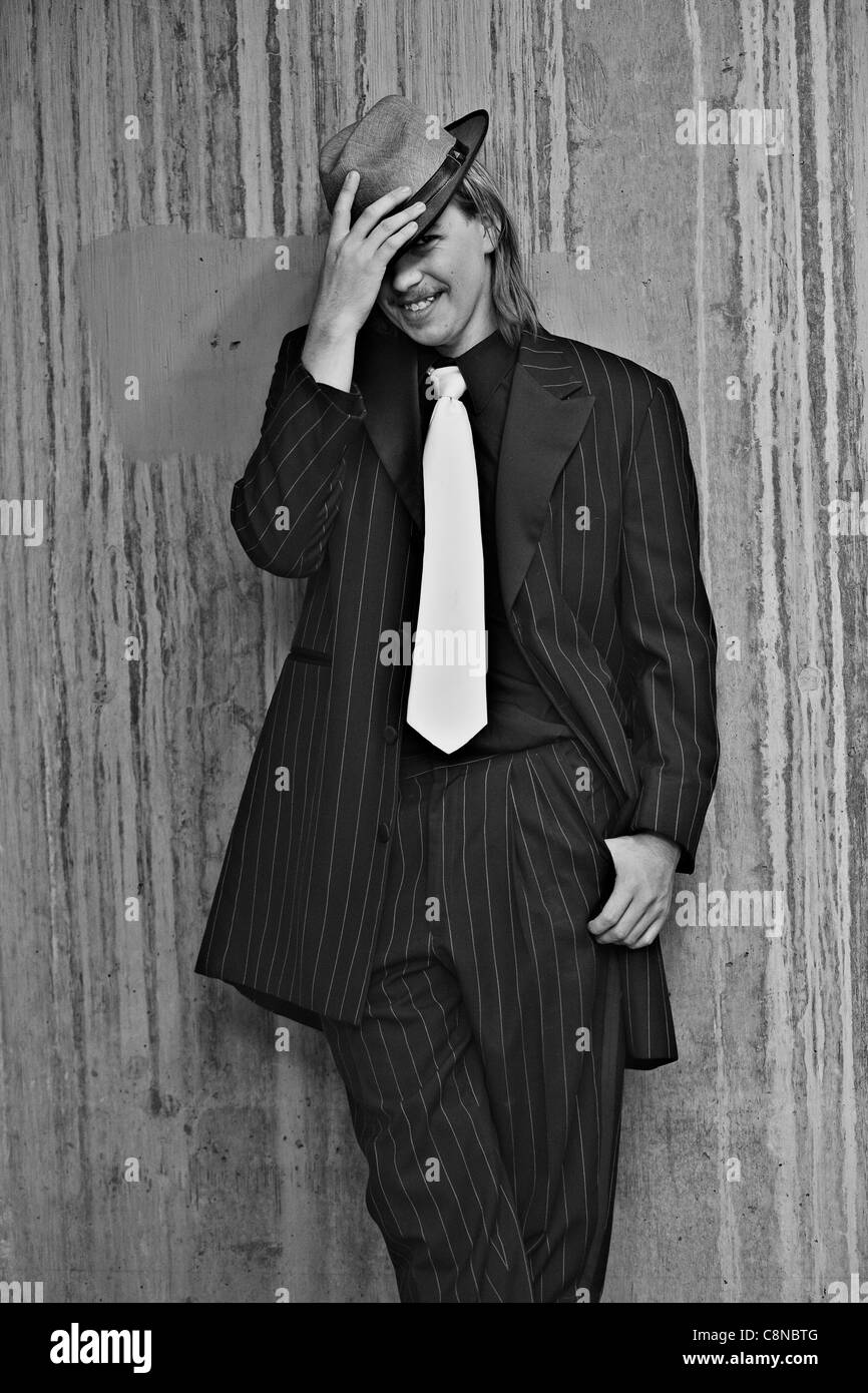 Immagine in bianco e nero di bel giovane uomo che indossa Zoot Suit prendendo in downtown. Foto Stock