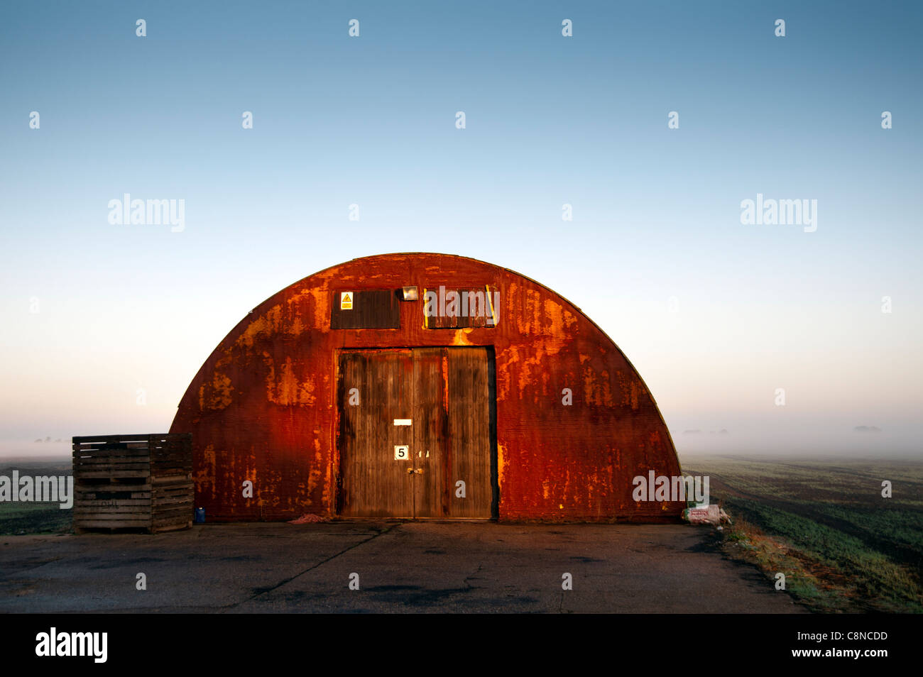 Nissen capanna fienile nel Fens su nebbiosa mattina autunnale. Foto Stock