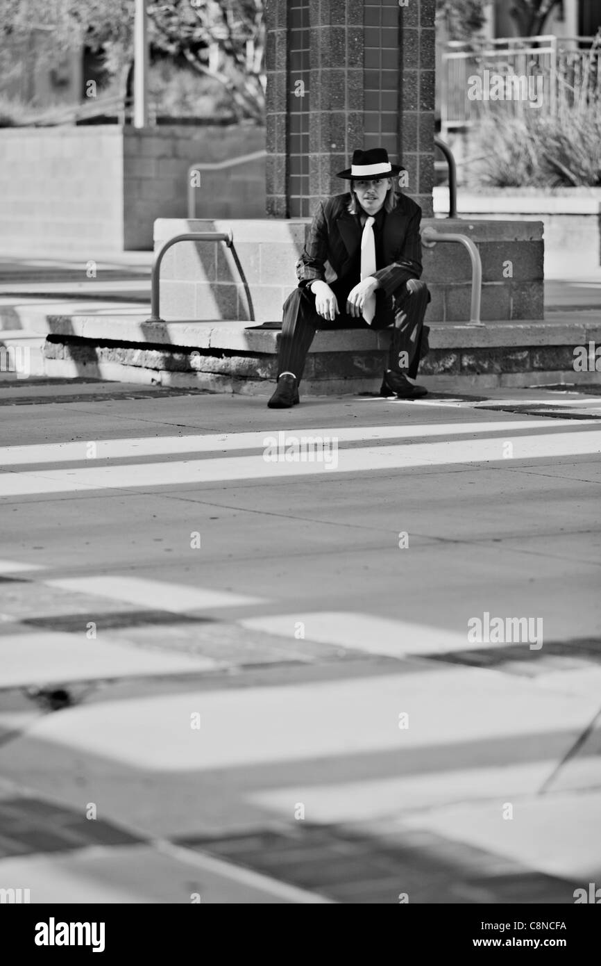Immagine in bianco e nero di bel giovane uomo che indossa Zoot Suit prendendo in downtown. Foto Stock