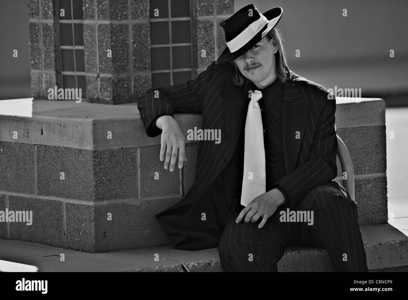 Ritratto di bel giovane in zoot suit, downtown. Indossa un cappello inclinato. Questa immagine viene fatto in b&w per effetto. Foto Stock