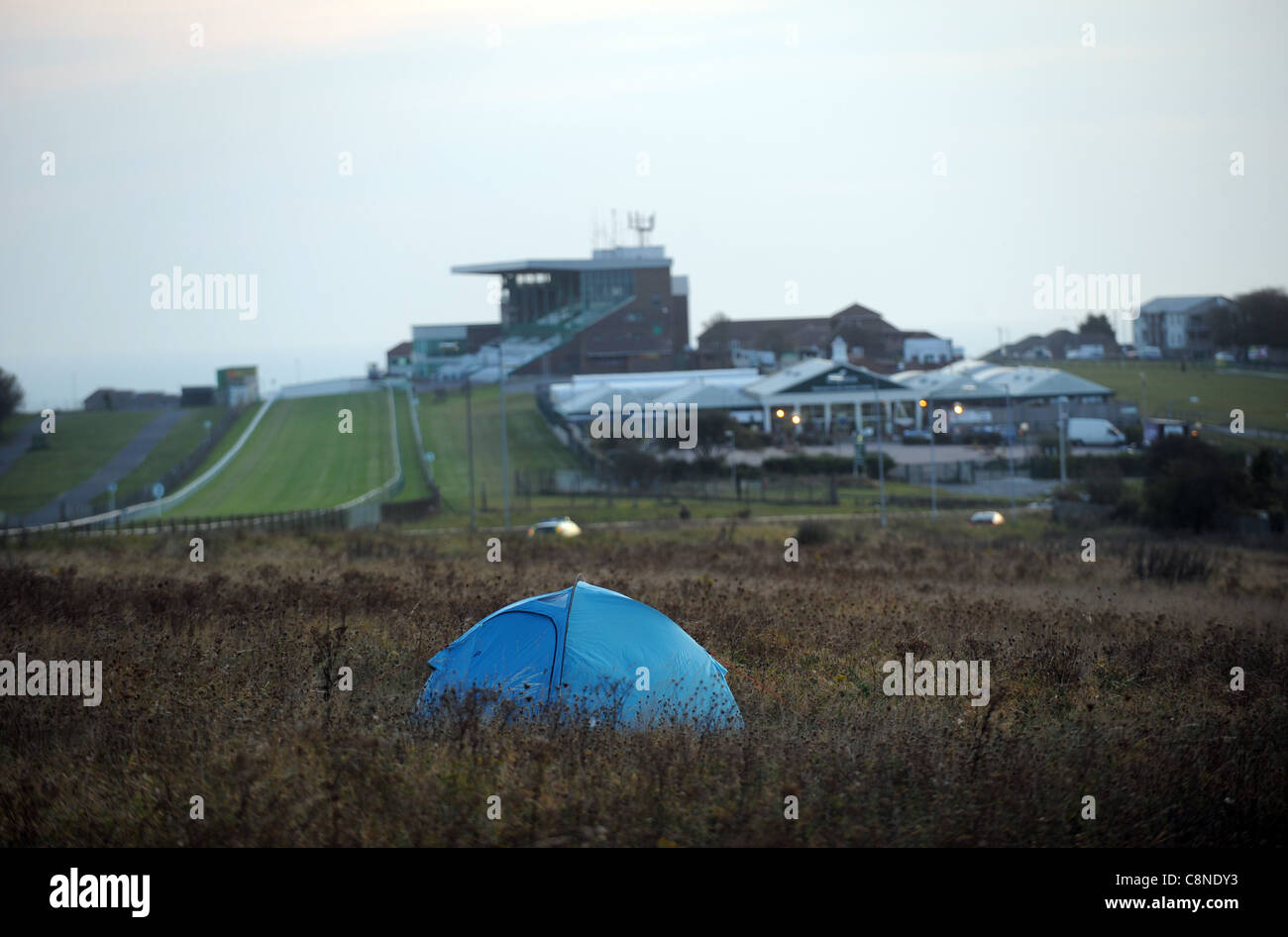 Piccola tenda con un solo uomo allestita su terreno desolato sopra le zone di Tenantry Down vicino all'ippodromo di Brighton Foto Stock