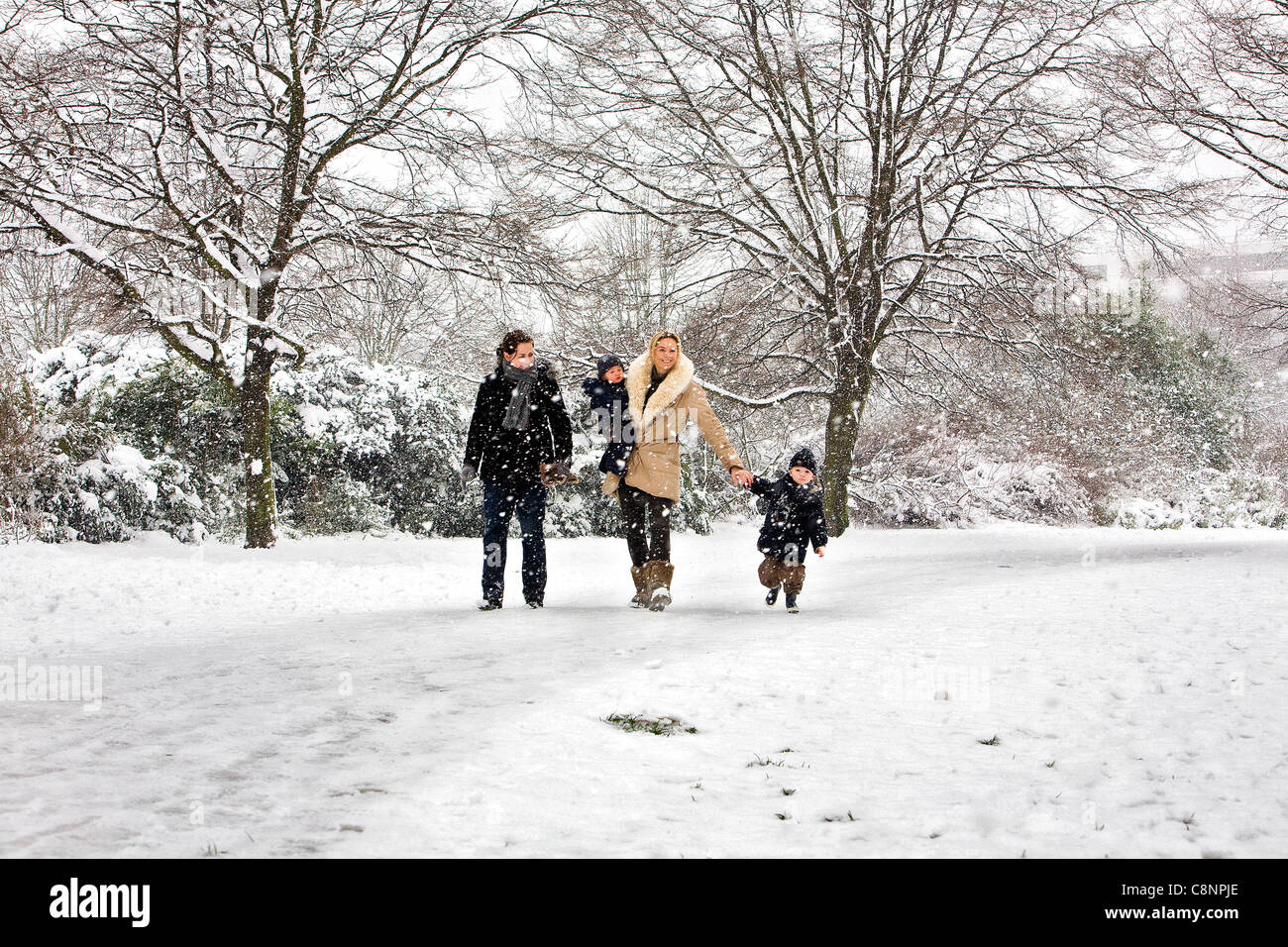 Mamma camminano con i suoi due figli e Au-pair in Hyde Park mentre nevicava. Foto Stock