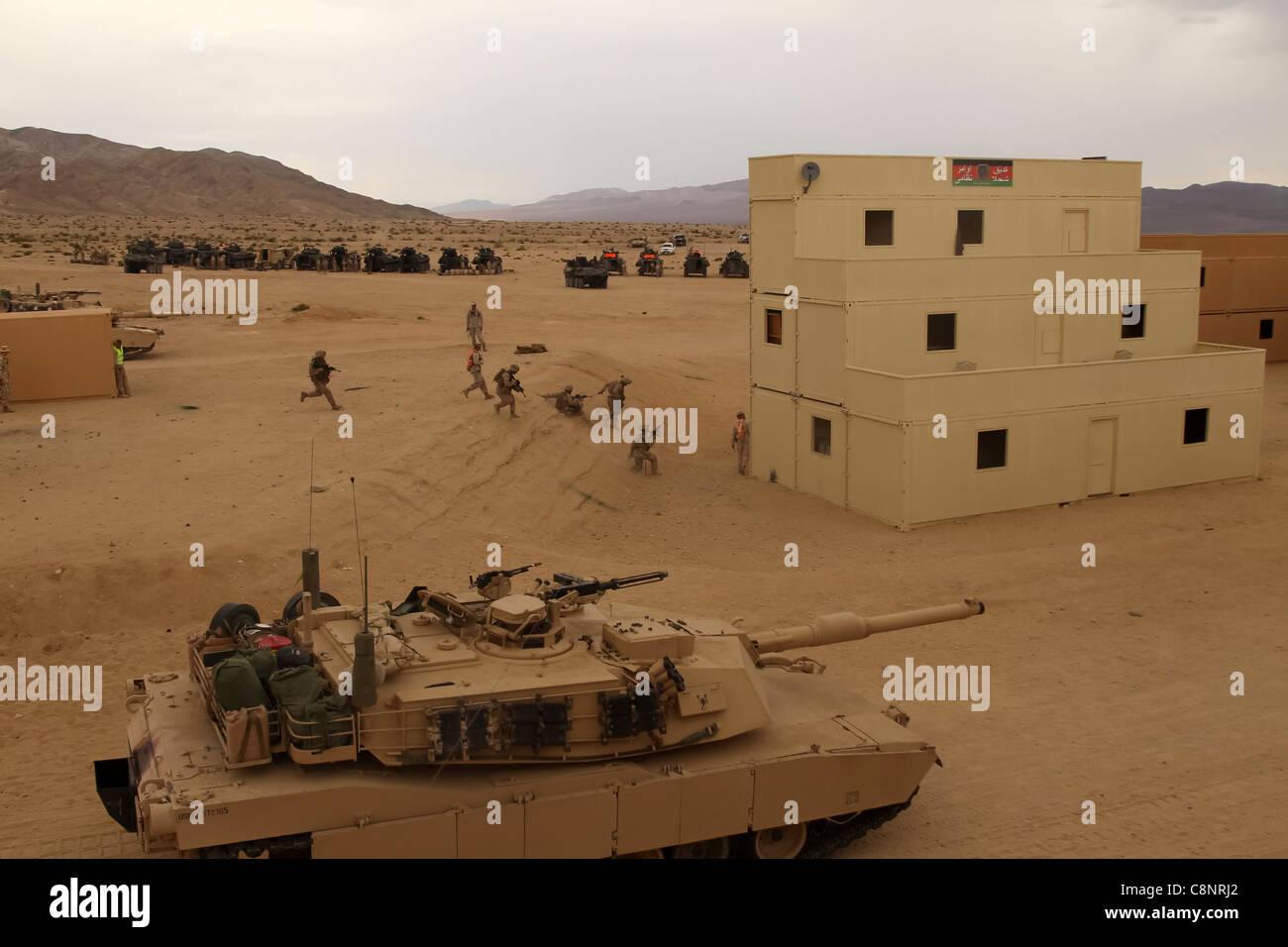 Un carro armato Abrams M1A1 con l'Azienda A, il primo battaglione di carri armati, fornisce supporto per i Marines del Battaglione di primo grado di Recontroricognizione blindata mentre i Marines di fanteria corrono verso l'obiettivo successivo durante la fase libera dell'addestramento migliorato di Mojave Viper a Range 220 Settembre 5, 2011. Foto Stock