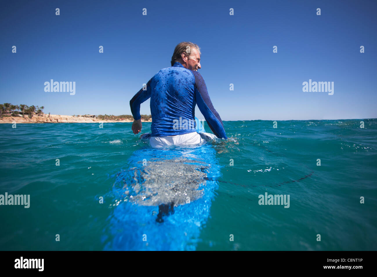 Uomo caucasico galleggiante sulla tavola da surf Foto Stock