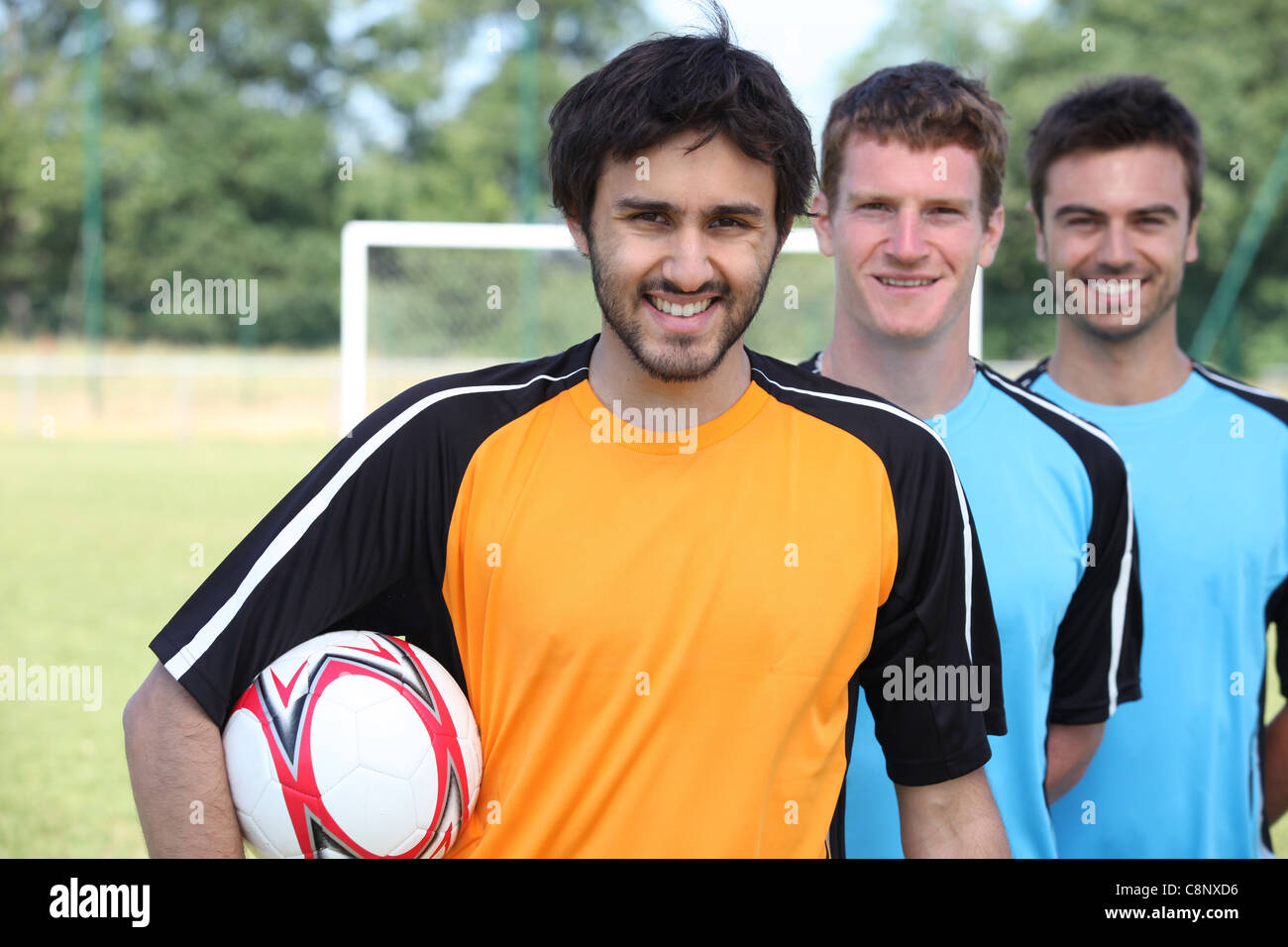 Tre i calciatori in una line-up di fronte all obiettivo Foto Stock