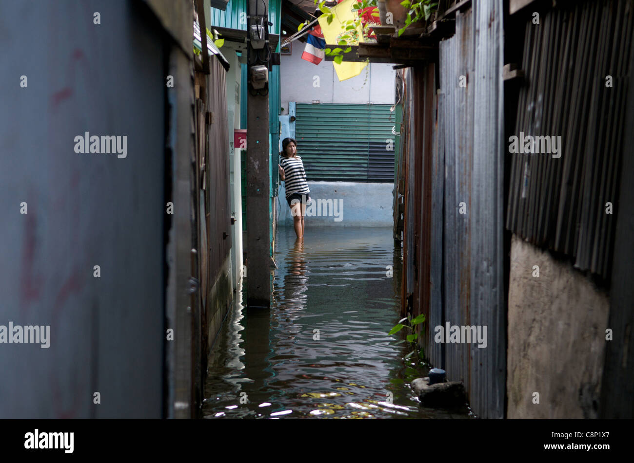 La donna tailandese si trova in acqua alluvionale dal canale Pak Kret, Bangkok, Thailandia, il 28 ottobre 2011. La Thailandia sta vivendo le sue peggiori inondazioni in 50 anni. © Kraig Lieb Foto Stock