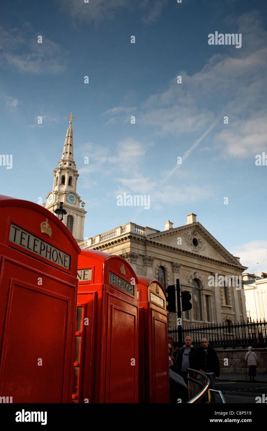 Rosso classico le cabine telefoniche di fronte a San Martin-in-the-Fields, Londra Foto Stock