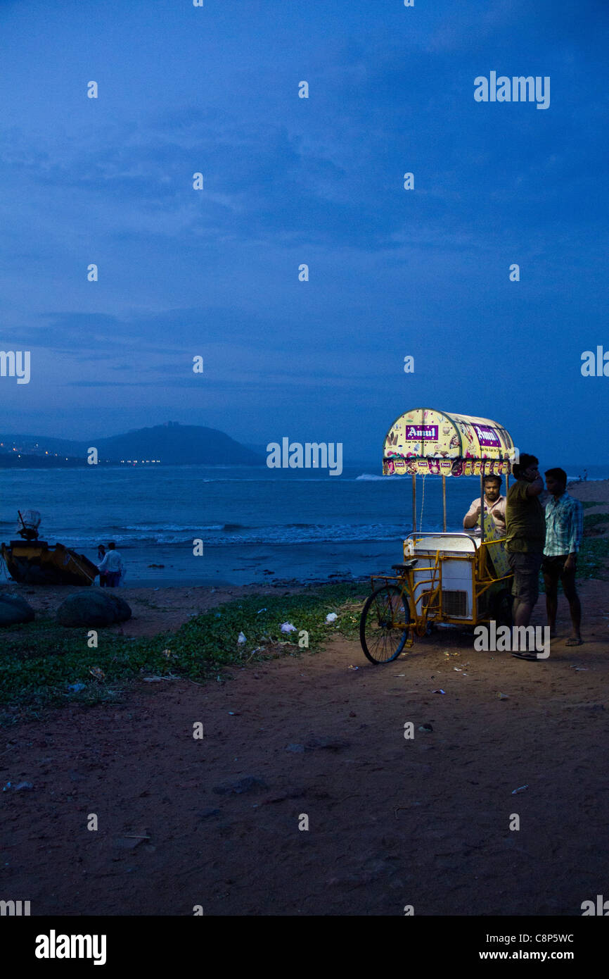 Due uomini acquisto di gelato subito dopo il tramonto a Rishikonda Beach‎ sulla città costiera di normalmente denominato Vizag Foto Stock