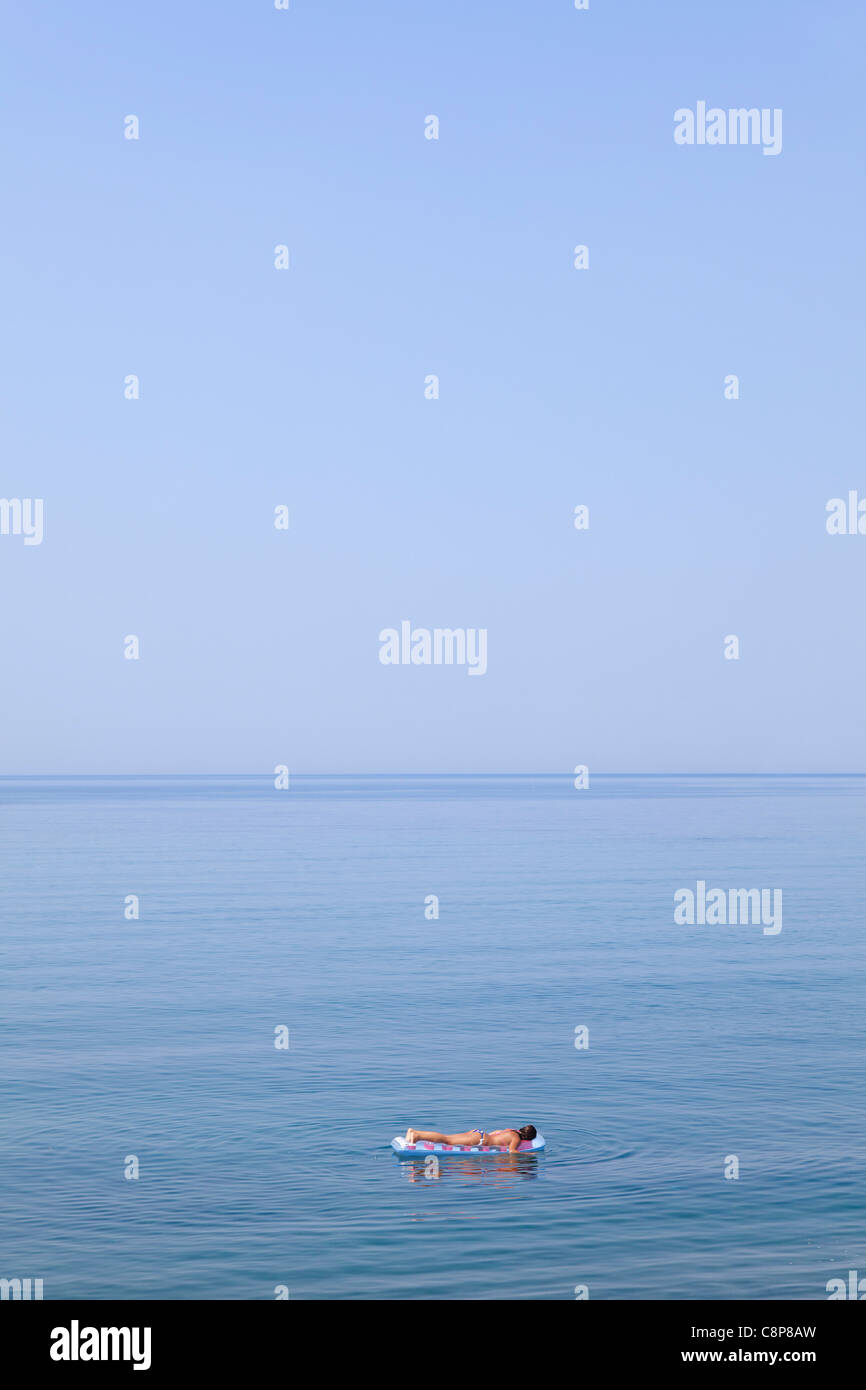 Galleggiante su un materasso ad aria con il blu del mare Foto Stock