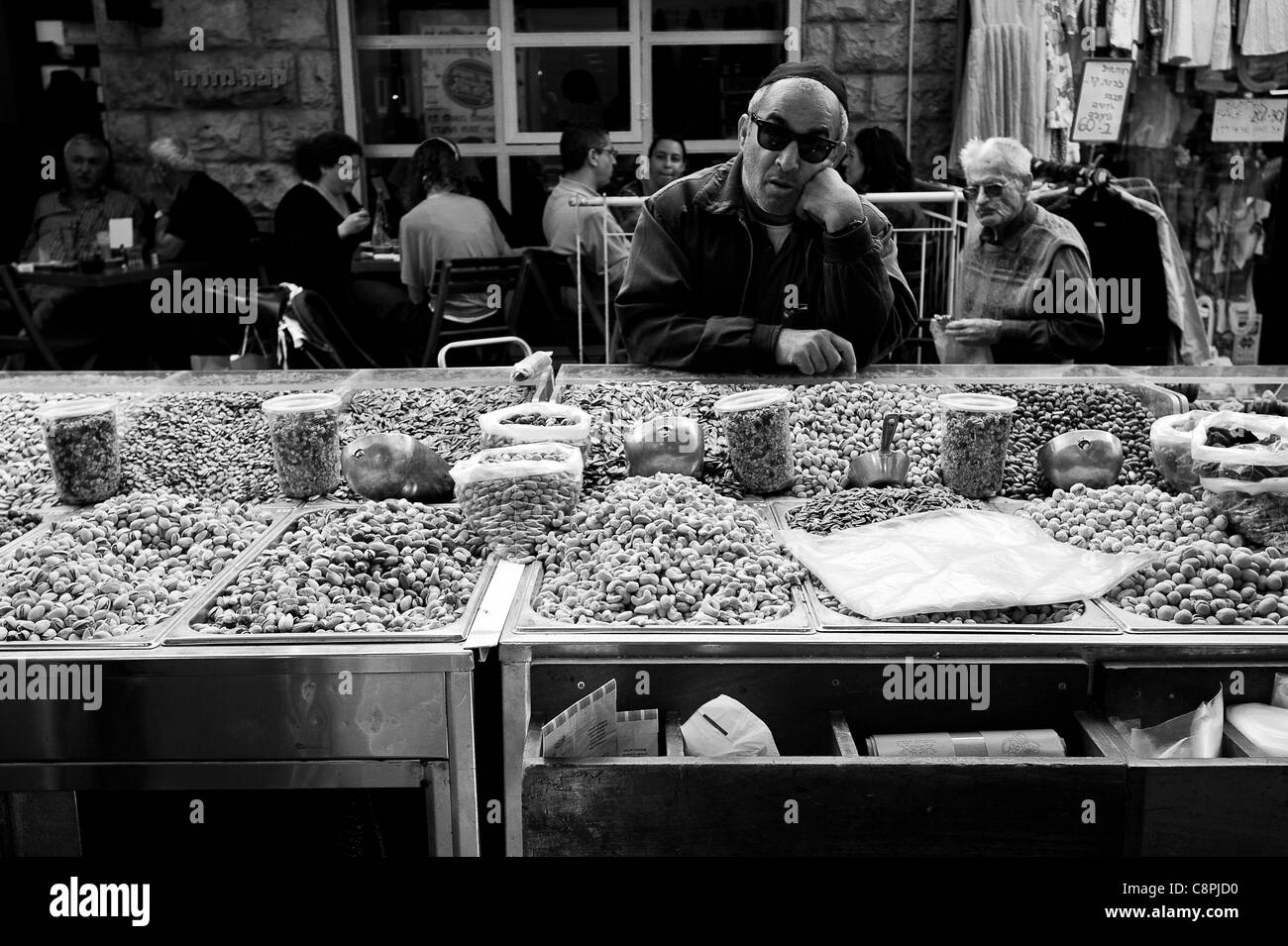 In piedi di fronte a un cavalletto di spezie nel mercato, sognando con occhiali da sole. Foto Stock