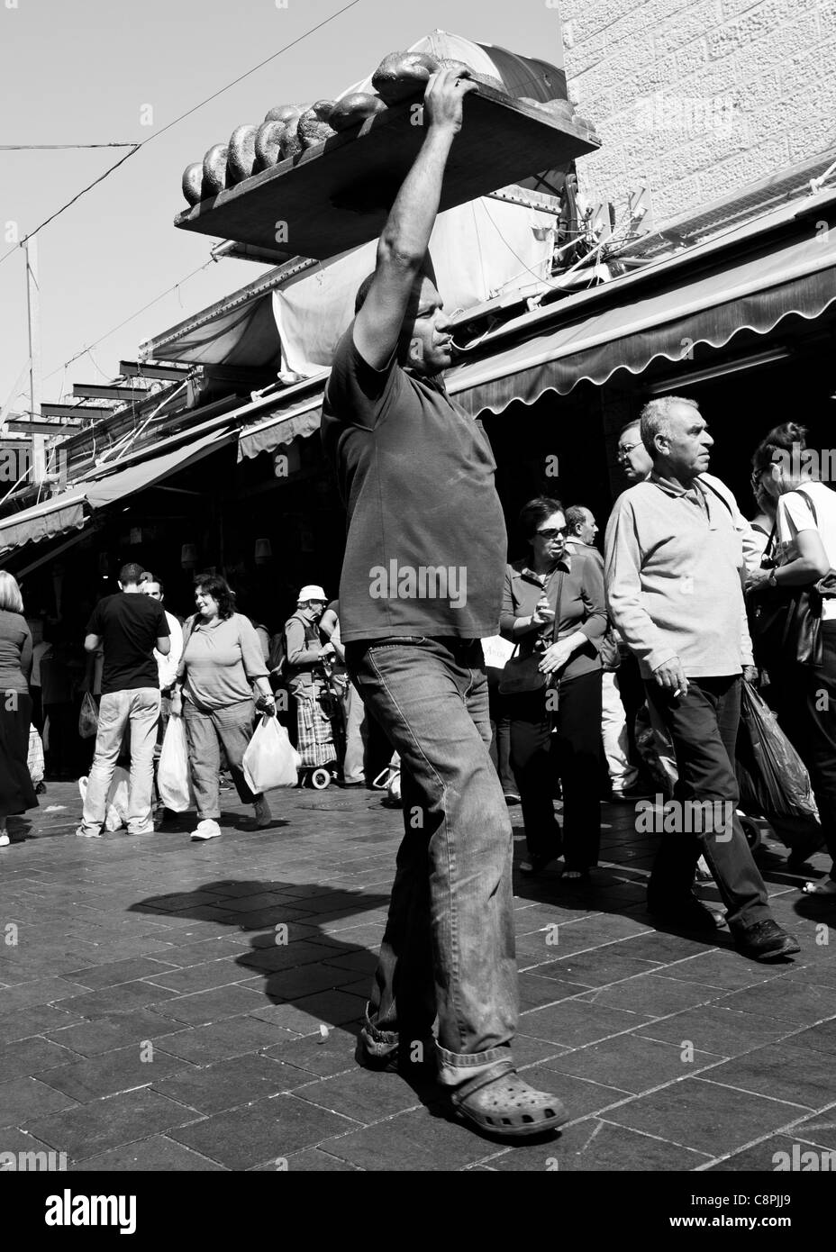 Un uomo che trasportava un carico di pane fresco dal forno Foto Stock