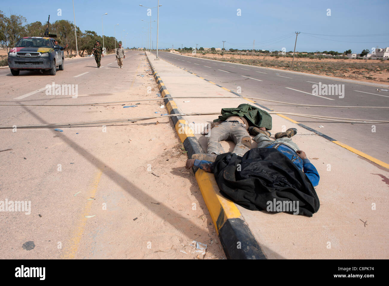 Uno del colonnello guardie Gaddafis stabilisce morti nelle strade su Sirt dopo una NATO aerei sciopero sul convoglio di Gheddafi. Foto Stock