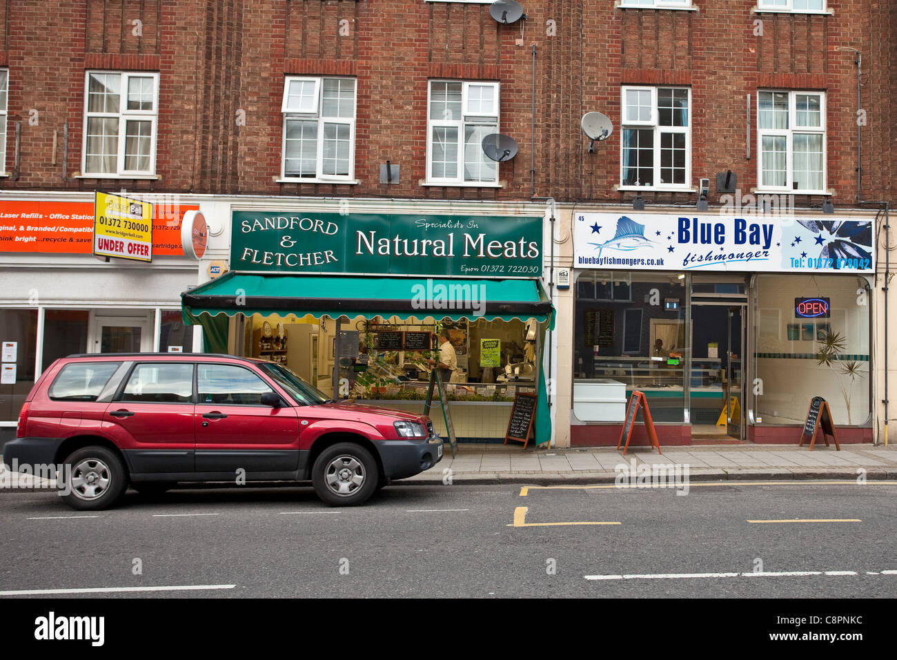 Butcher e adiacente pescivendolo a Epsom Surrey, 2011 Foto Stock