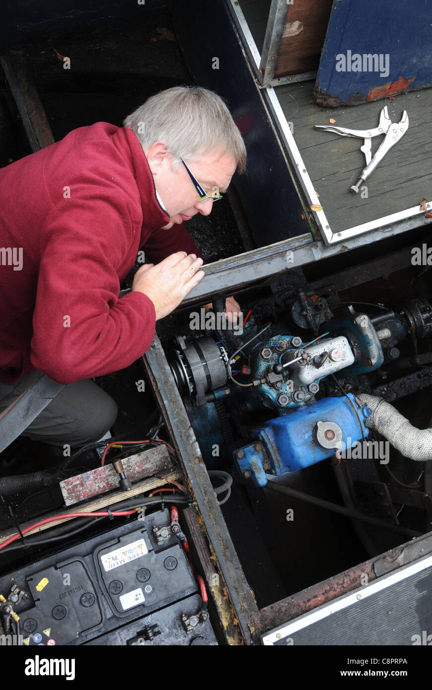 Uomo al lavoro su Canal Boat NARROWBOAT CHIATTA MOTORE DIESEL CON STRUMENTI RI NAUTICA VACANZA Manutenzione guasti ETC REGNO UNITO Foto Stock