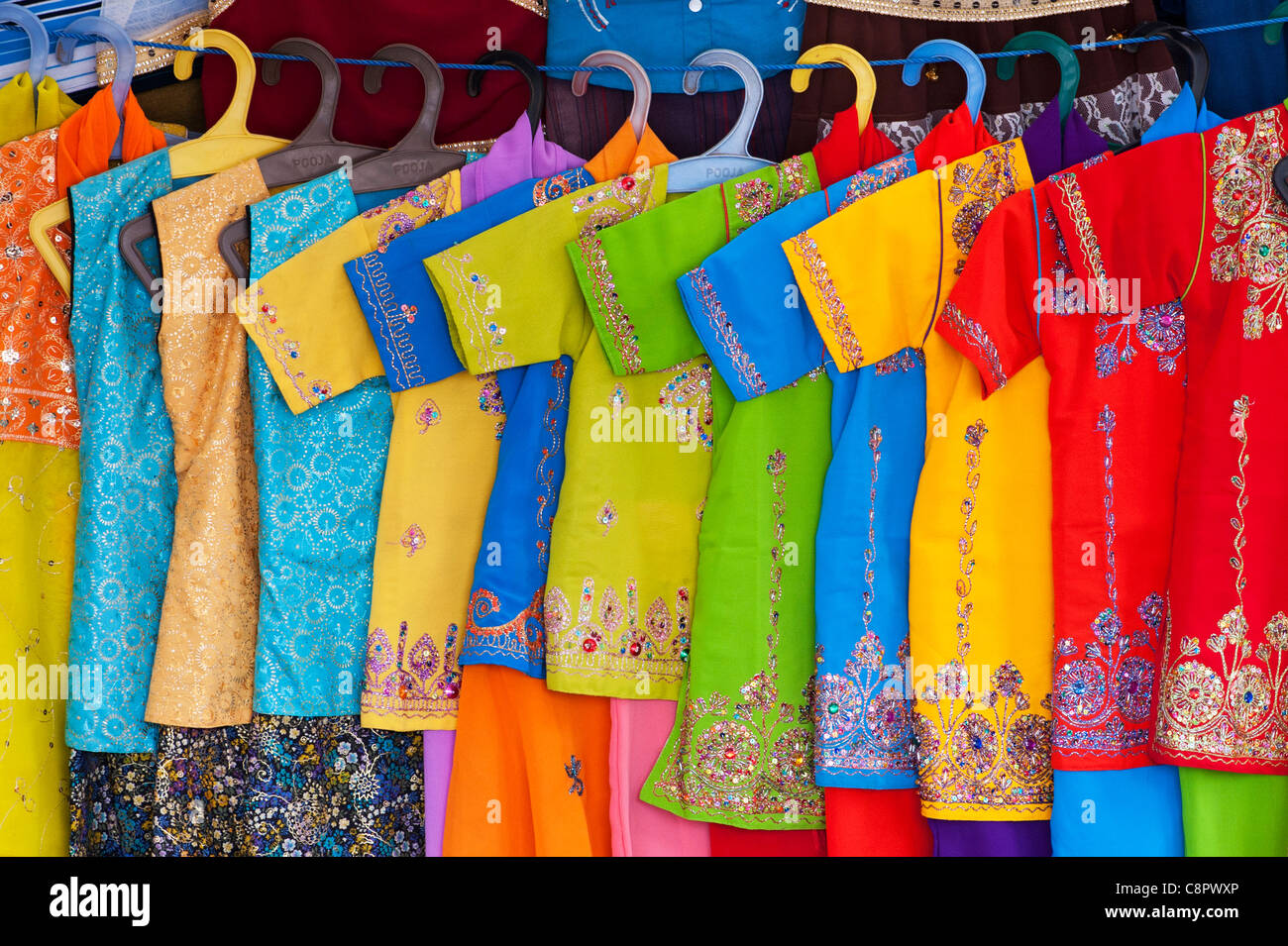 Colorate indiano appendere abiti per bambini in un mercato indiano. Andhra Pradesh, India Foto Stock