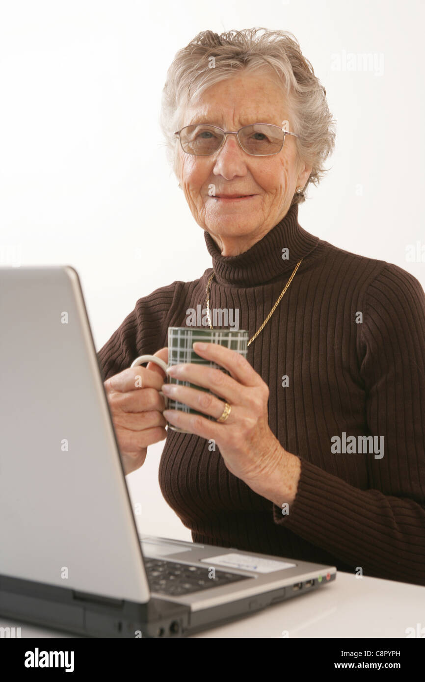 Un'anziana donna che utilizza un computer portatile. Foto Stock