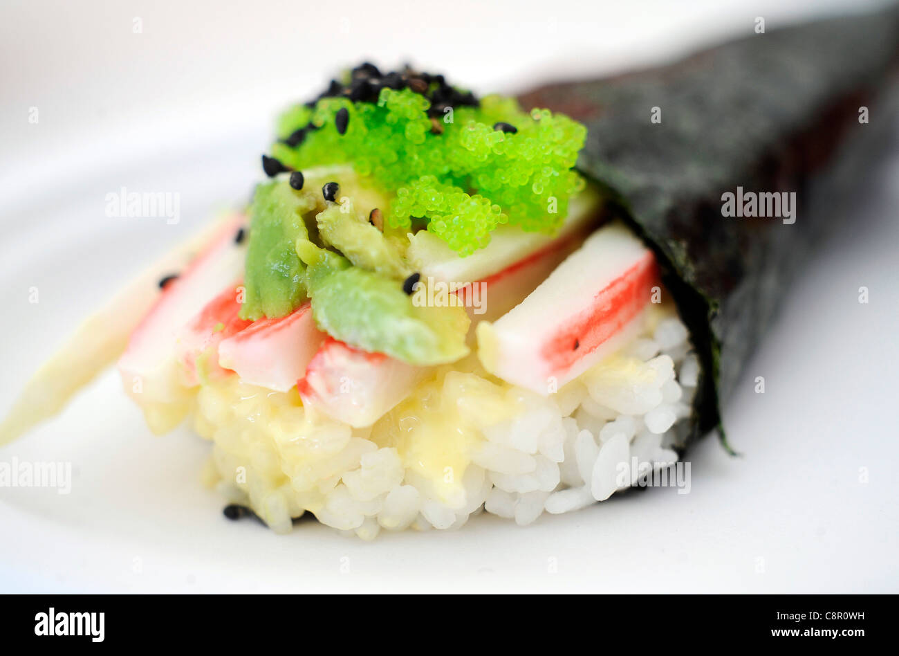Close up della California Roll sushi. Crabsicks, avocado riso e semi di sesamo avvolto in alghe marine. Foto Stock