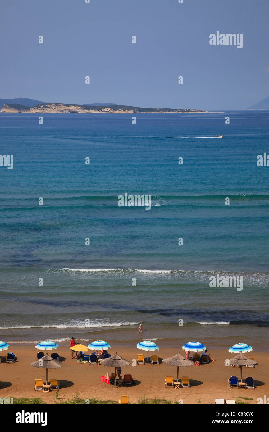 Agios Stephanos spiaggia con lettini e turisti, vista attraverso il Mediterraneo, Corfù, Grecia Foto Stock